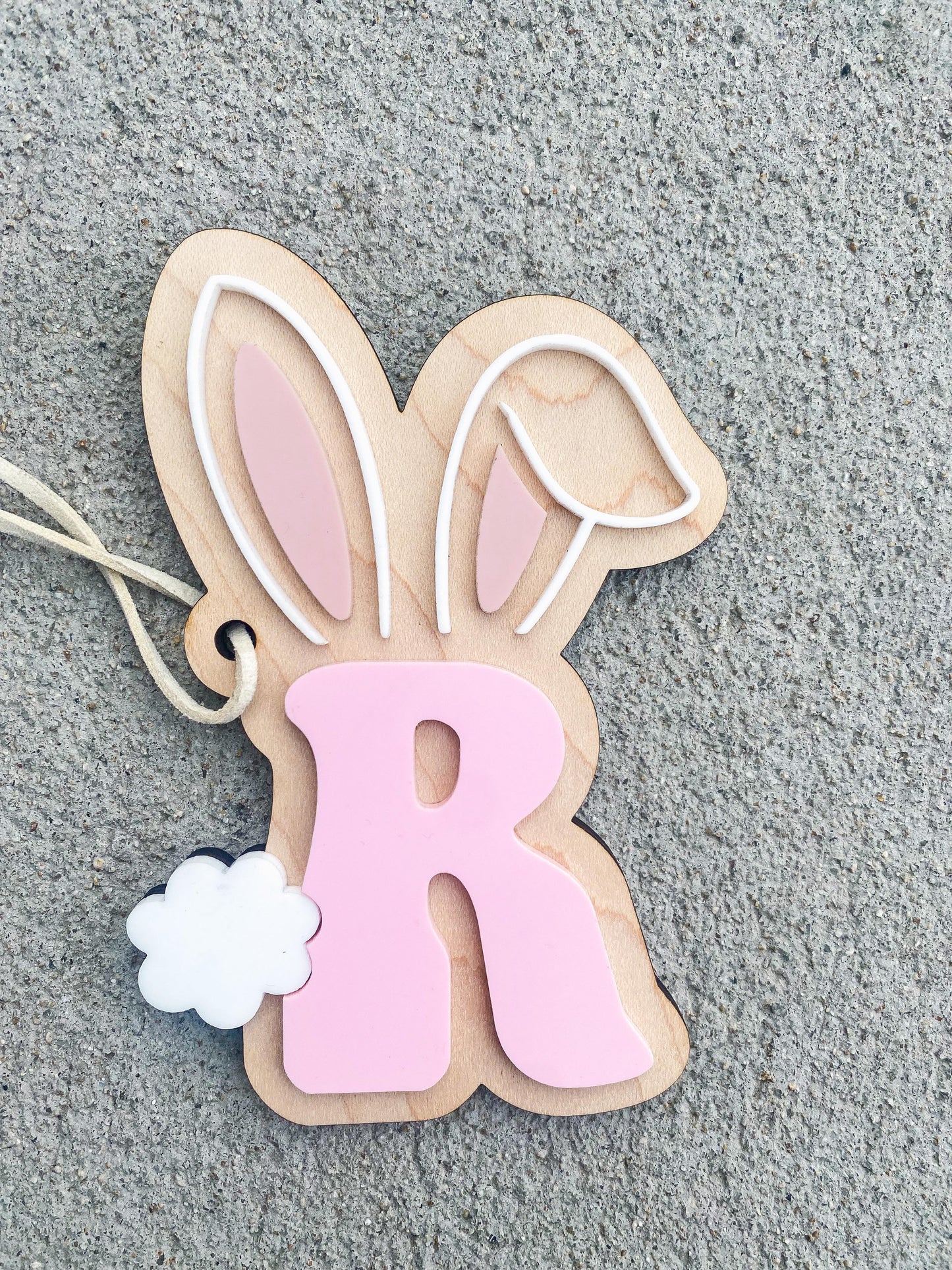 Close-up of initial Easter bunny basket tag with engraved letter detail