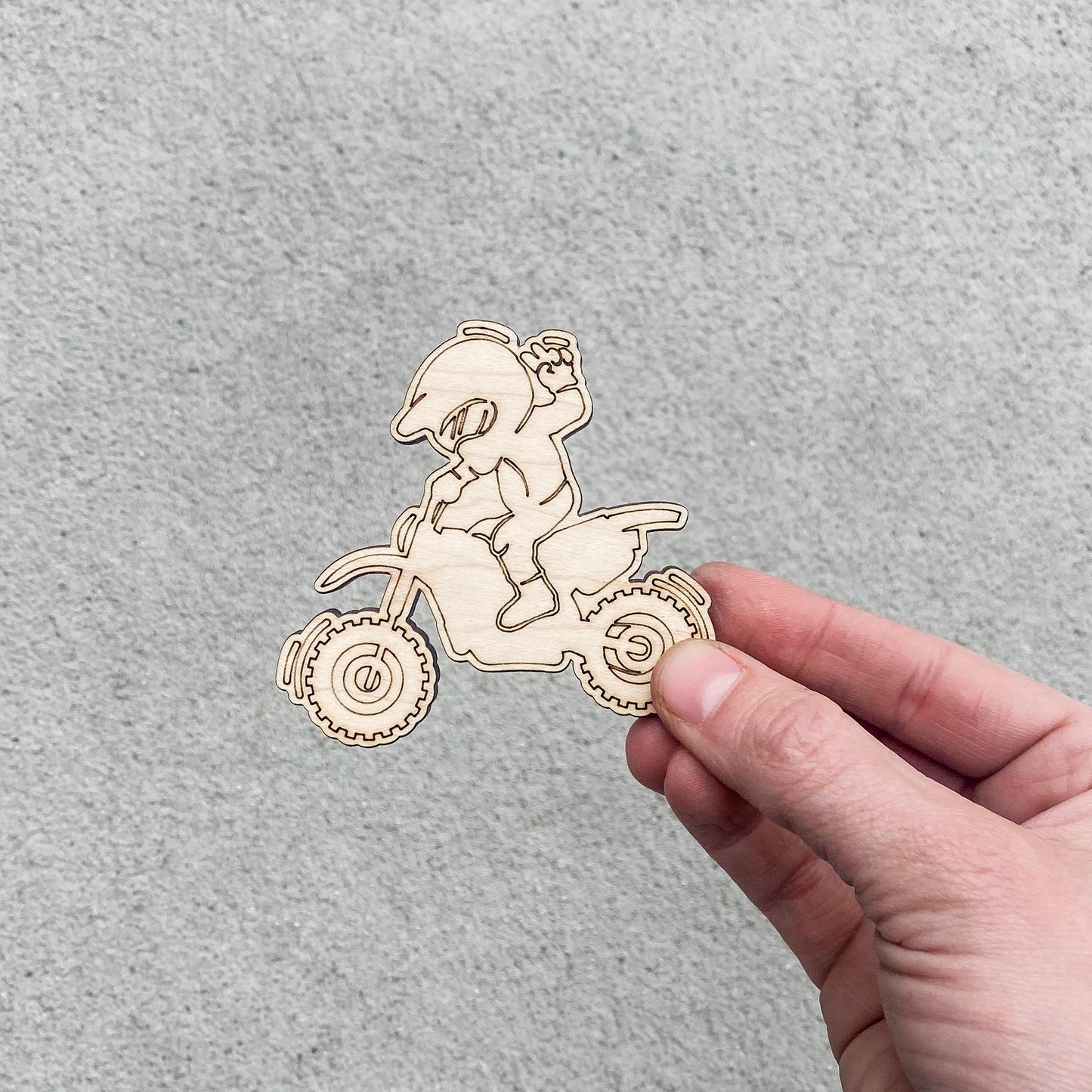 Dirt bike party favor showing wooden dirt bike shape, marker, and cellophane packaging
