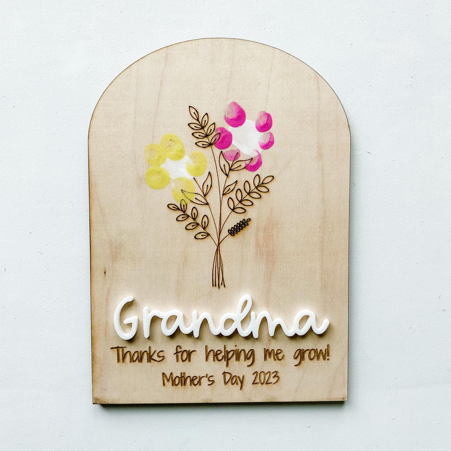 Personalized fingerprint flower sign for Mom and Grandma showing fingerprint artwork on wood
