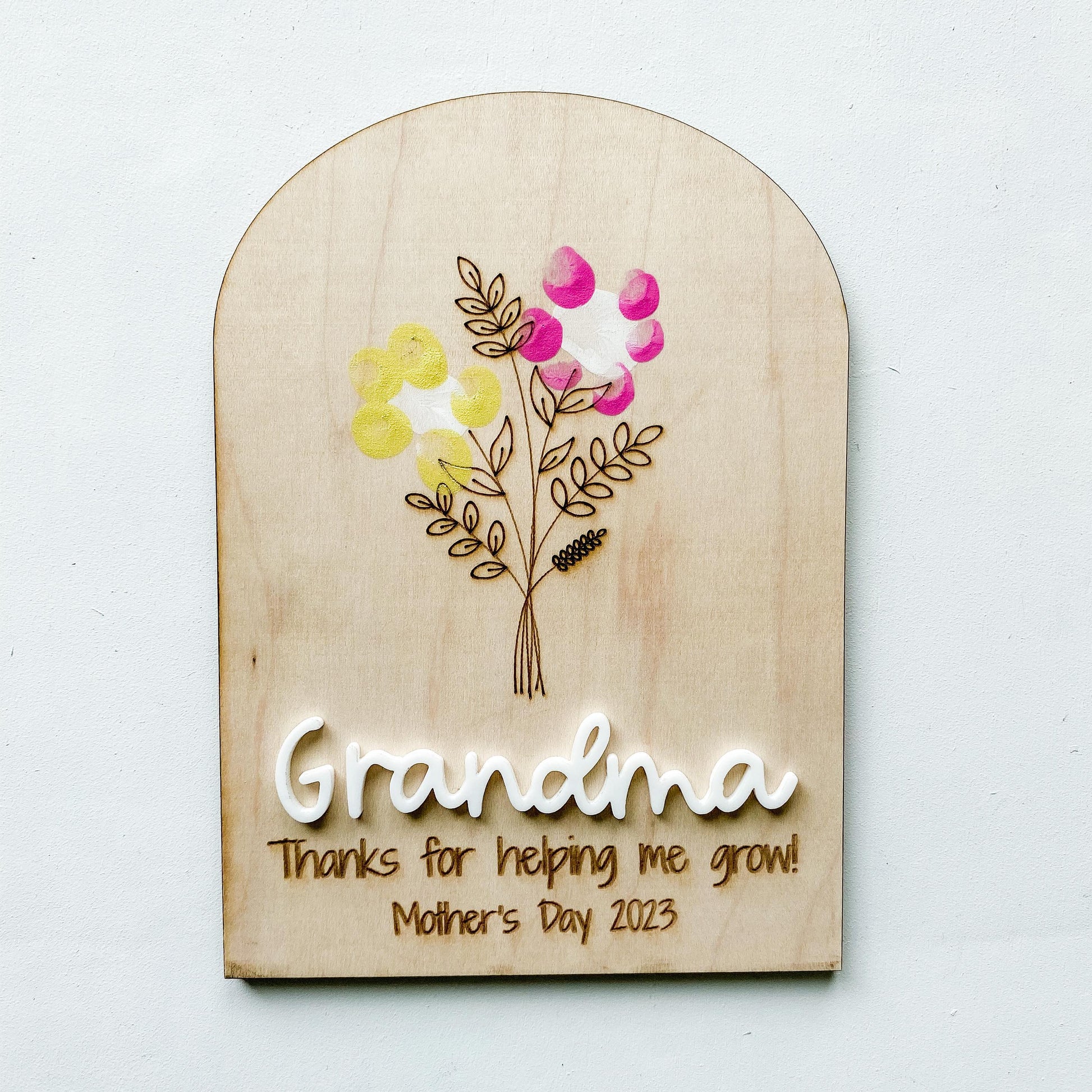 Personalized fingerprint flower sign for Mom and Grandma showing fingerprint artwork on wood