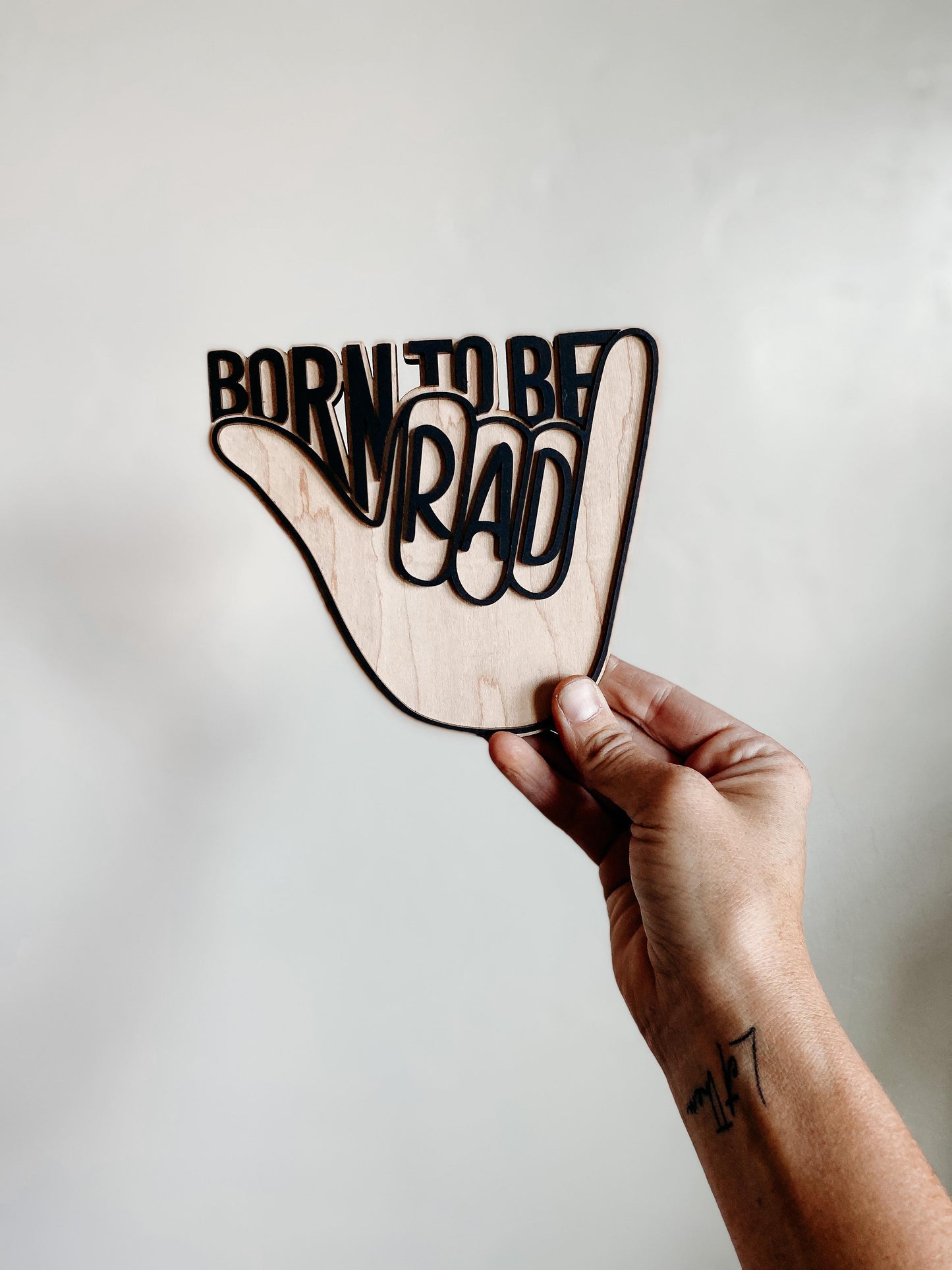 Born To Be Rad wooden nursery sign showing engraved lettering and natural wood grain