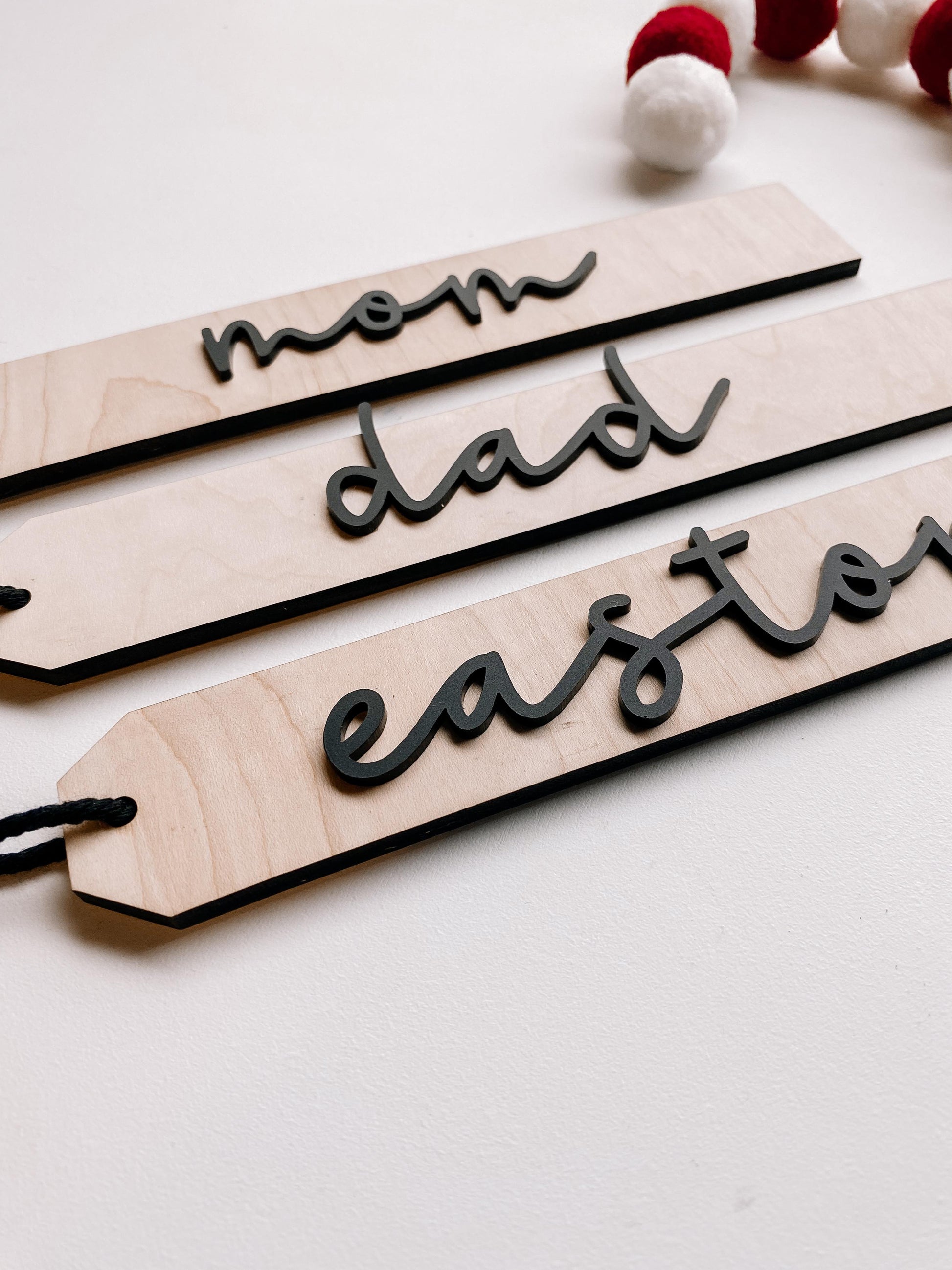 Personalized boho Christmas stocking tags displayed on holiday mantel