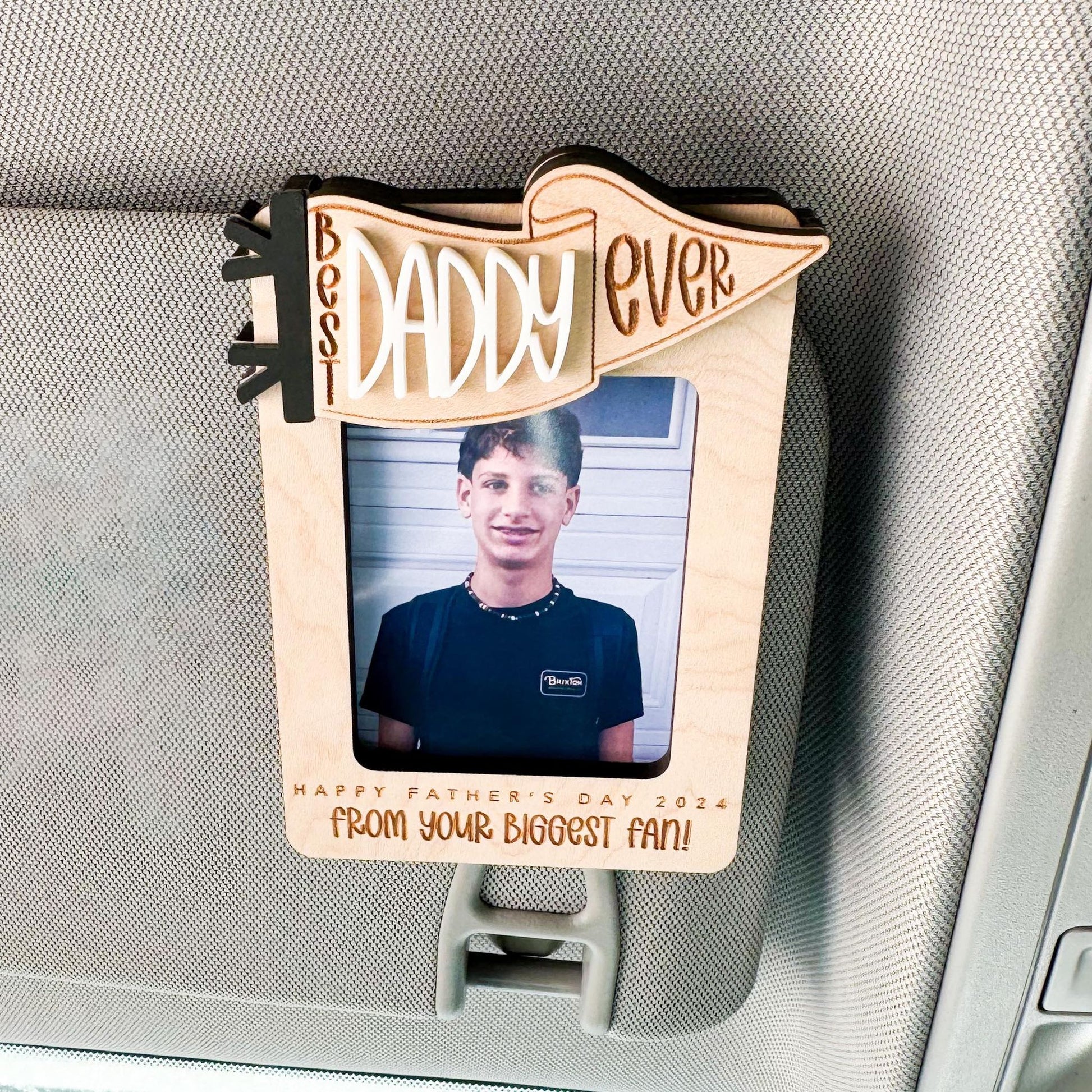 Close-up of Best Dad Ever visor clip showing metal clip and photo slot detail