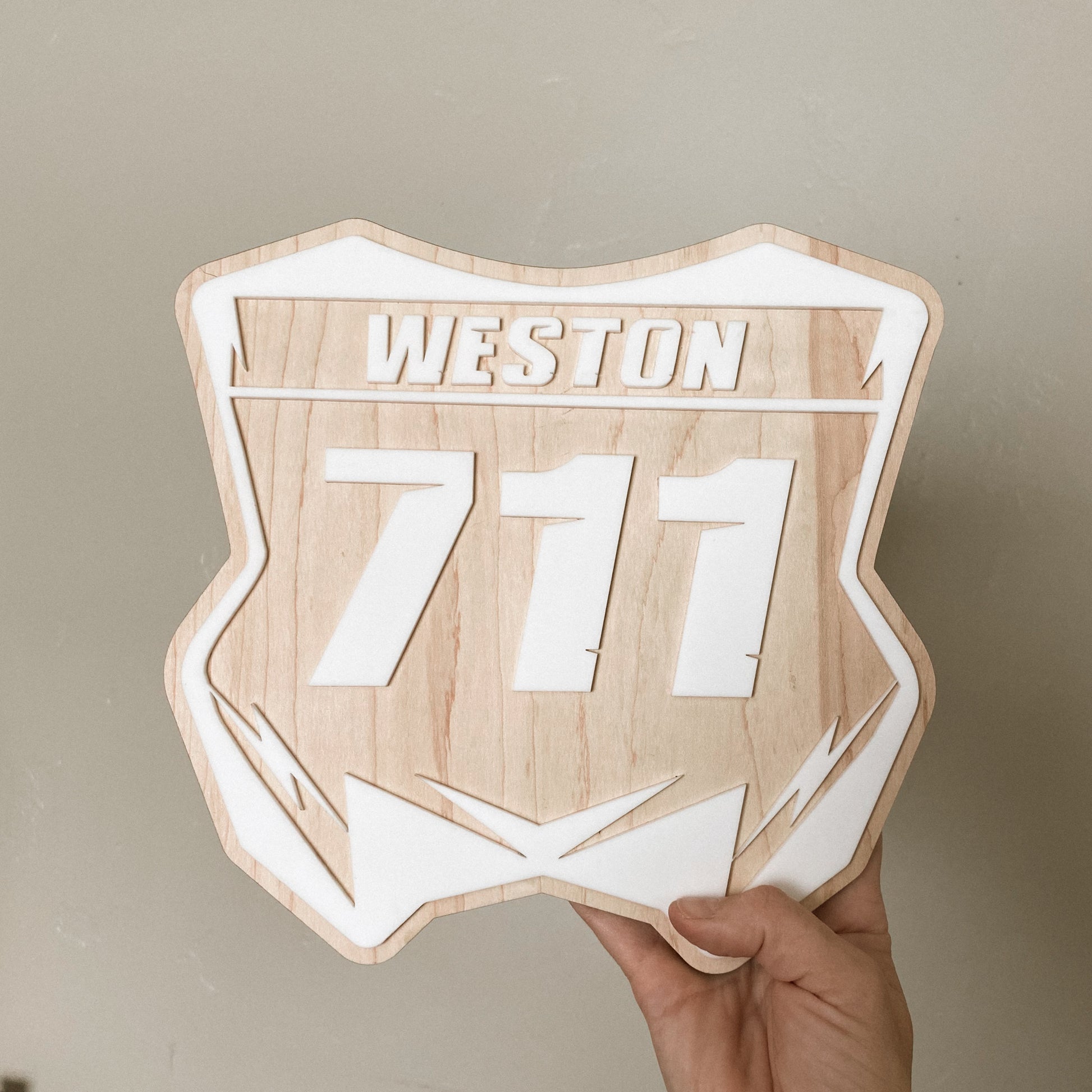 Close-up of personalized dirt bike number plate wall sign in natural maple wood