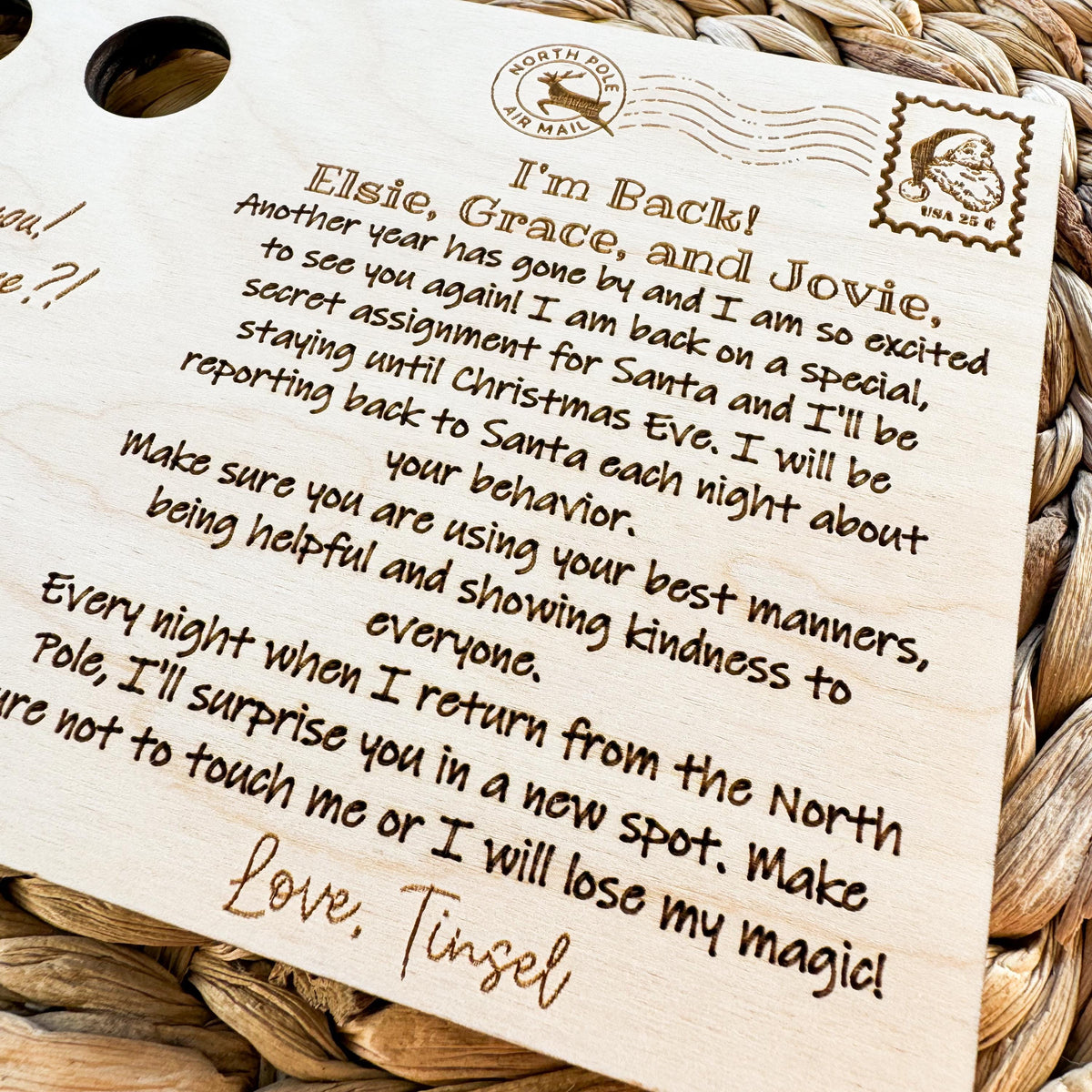 Close-up of the laser engraved elf welcome back message with personalized names and a North Pole postmark design