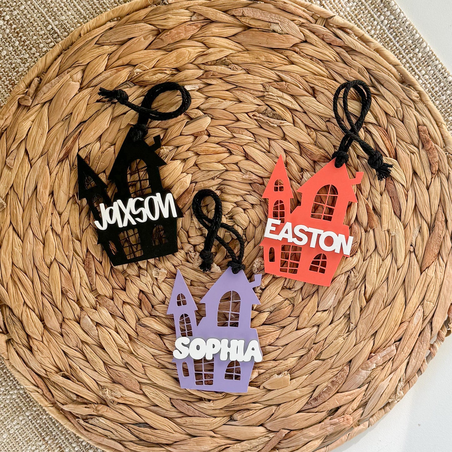 Personalized acrylic Halloween basket tags displayed with custom names for trick-or-treat bags