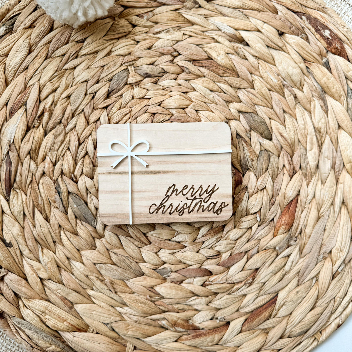 Merry Christmas money holder in natural maple wood with a white acrylic ribbon and bow, a reusable wooden box for gifting cash or a gift card