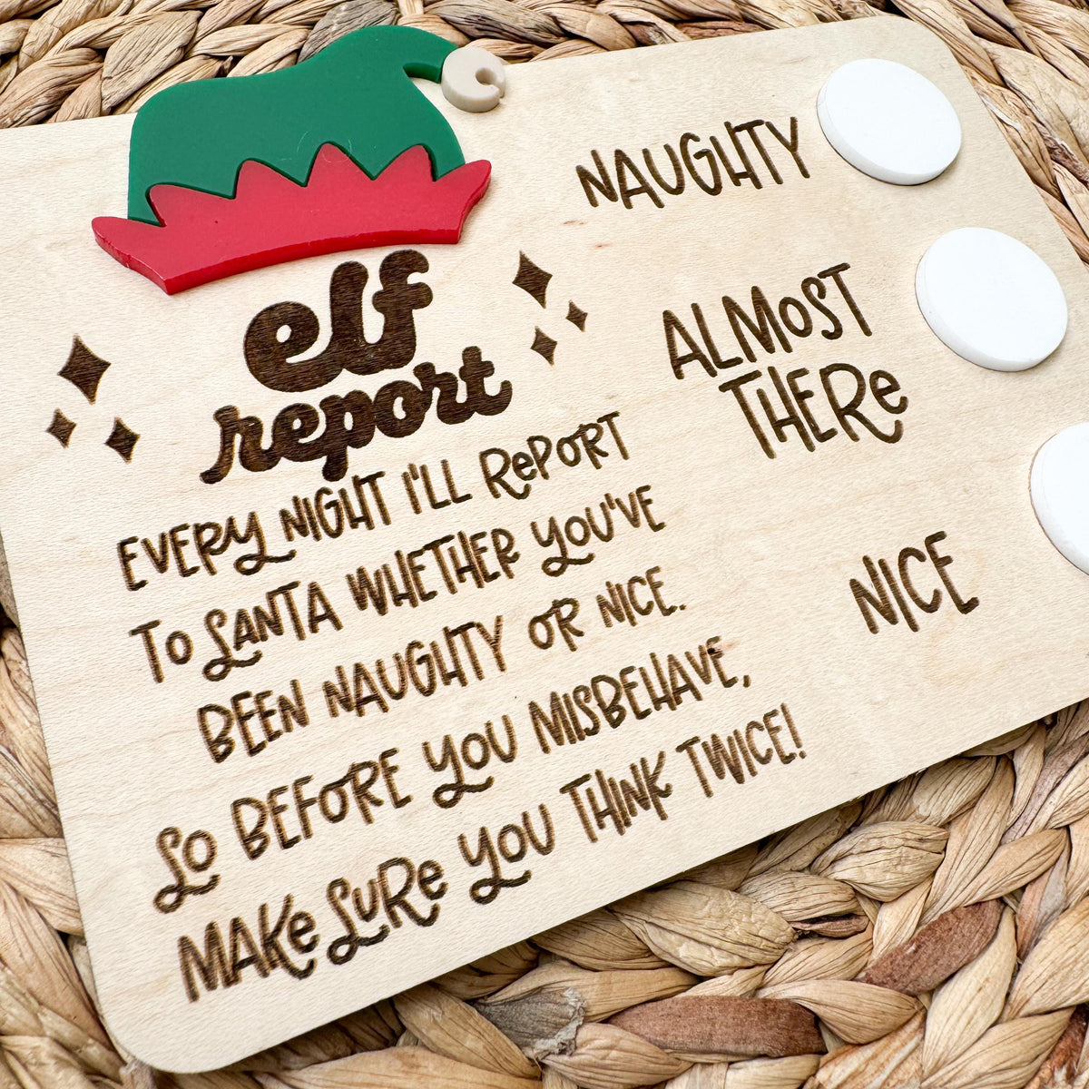 Close-up of the engraved elf report message reminding kids the elf reports to Santa whether they've been naughty or nice