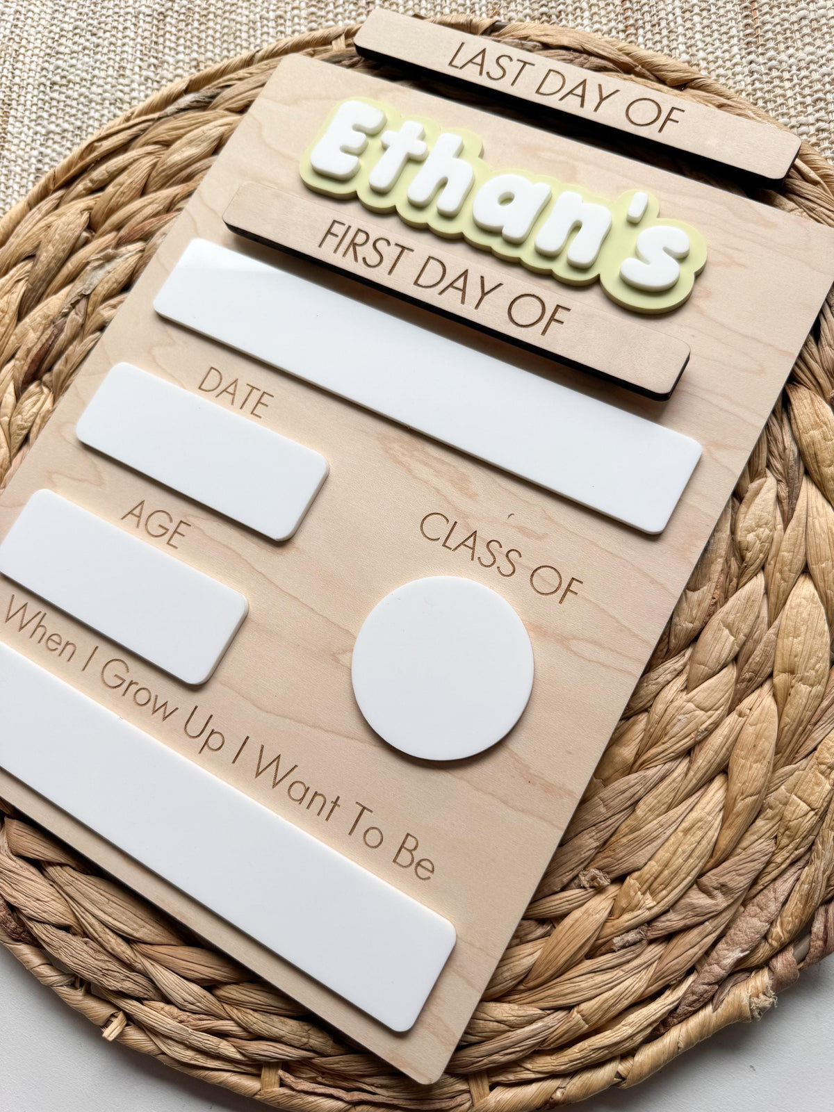 Detailed view of the reusable school milestone board showing dry erase writing areas, engraved labels, layered acrylic name, and natural wood finish.