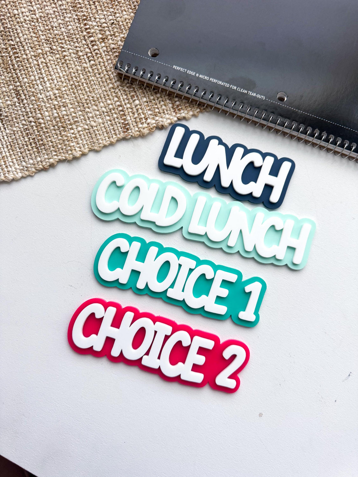 Layered acrylic lunch choice magnets - Cold Lunch, Choice 1, and Choice 2 labels in teal, blue, and red with white lettering