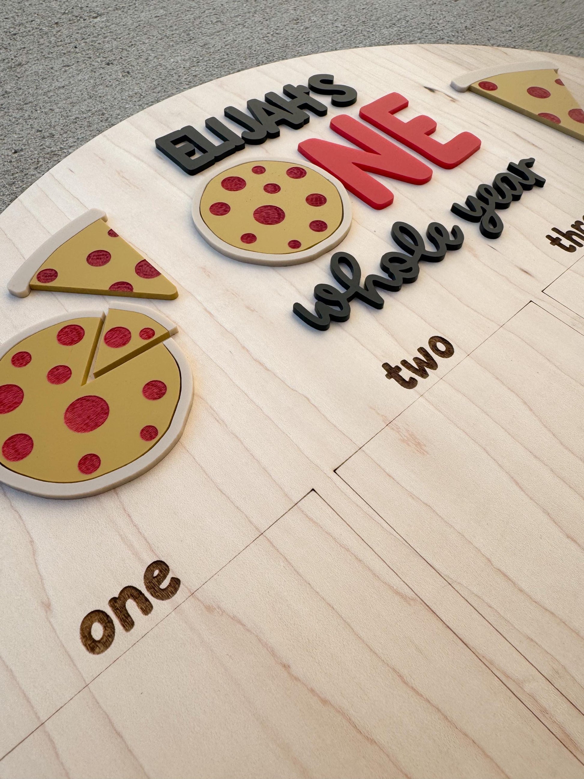 Close-up of pizza first year photo board with personalized name and pizza design