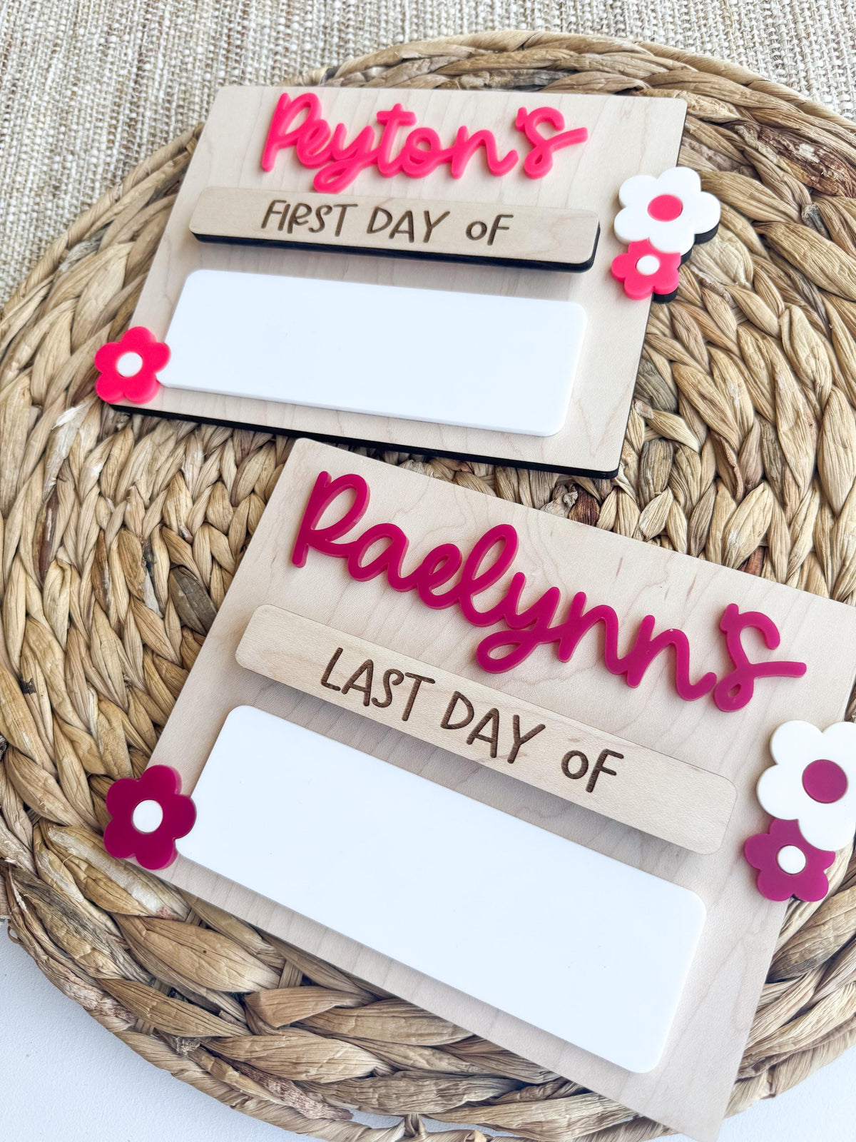 Close-up of layered acrylic lettering and flower details on custom school milestone signs.