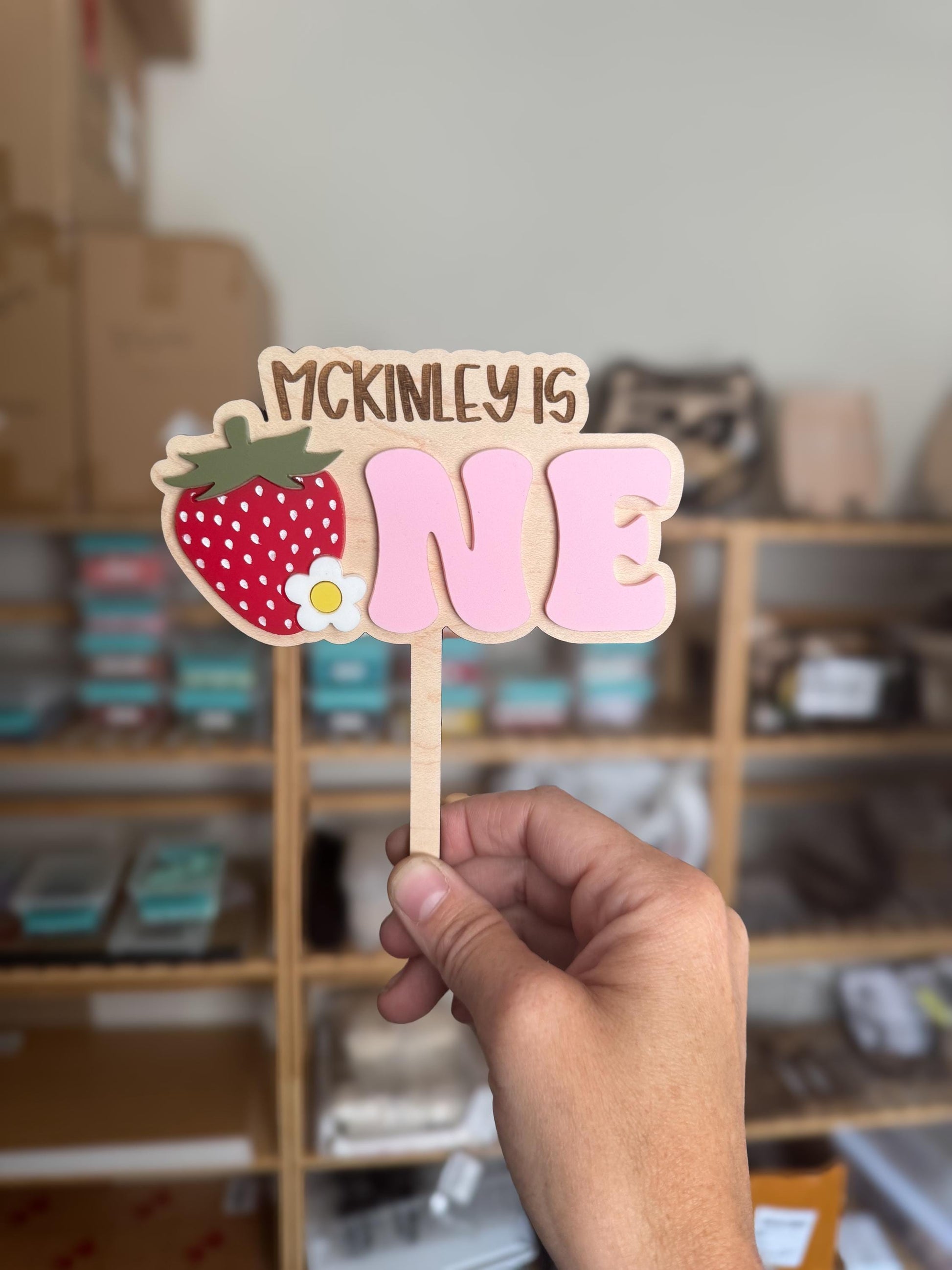 Strawberry ONE birthday topper showing layered wood and acrylic construction
