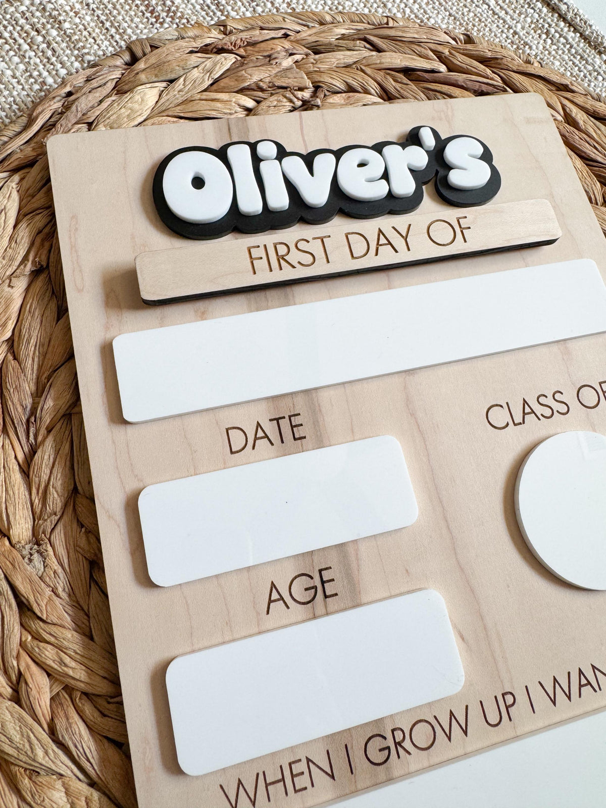 Detailed view of the reusable school milestone board showing dry erase writing areas, engraved labels, layered acrylic name, and natural wood finish.