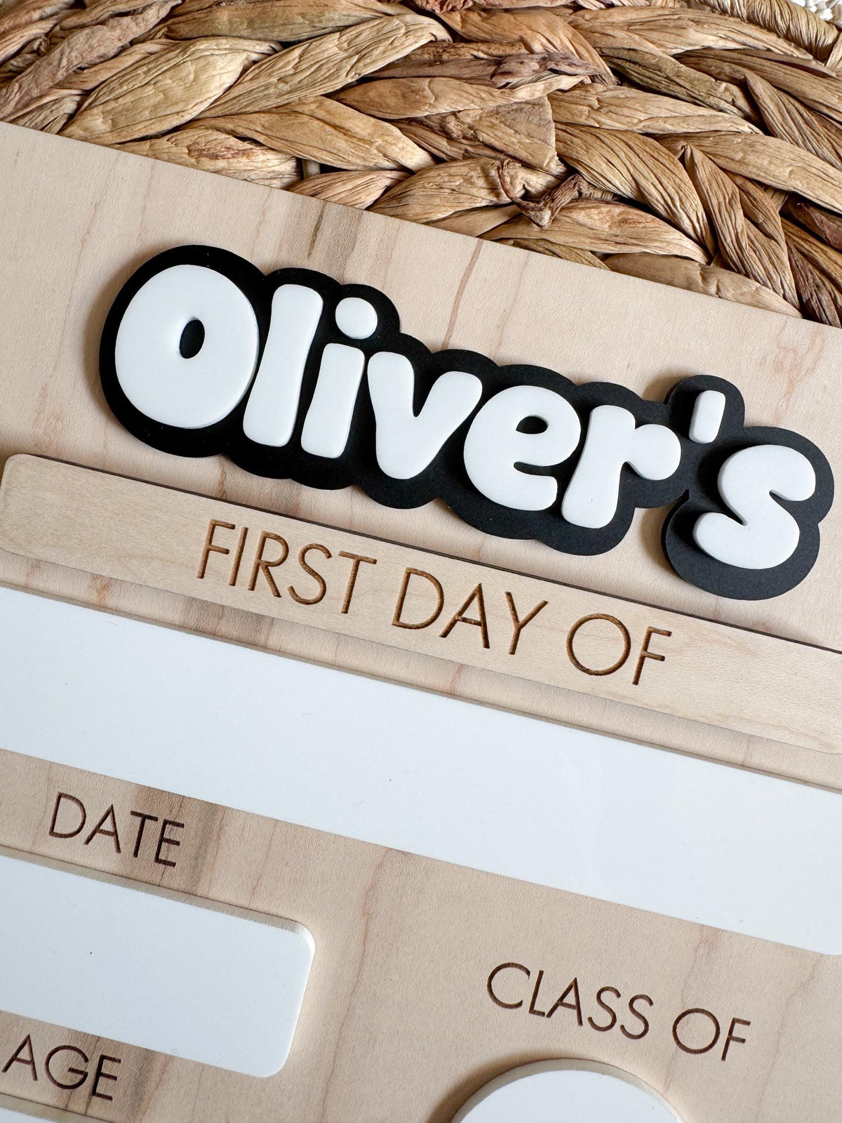 Close-up view of layered acrylic name on a personalized wooden school milestone sign, highlighting the dimensional lettering and smooth maple wood grain.