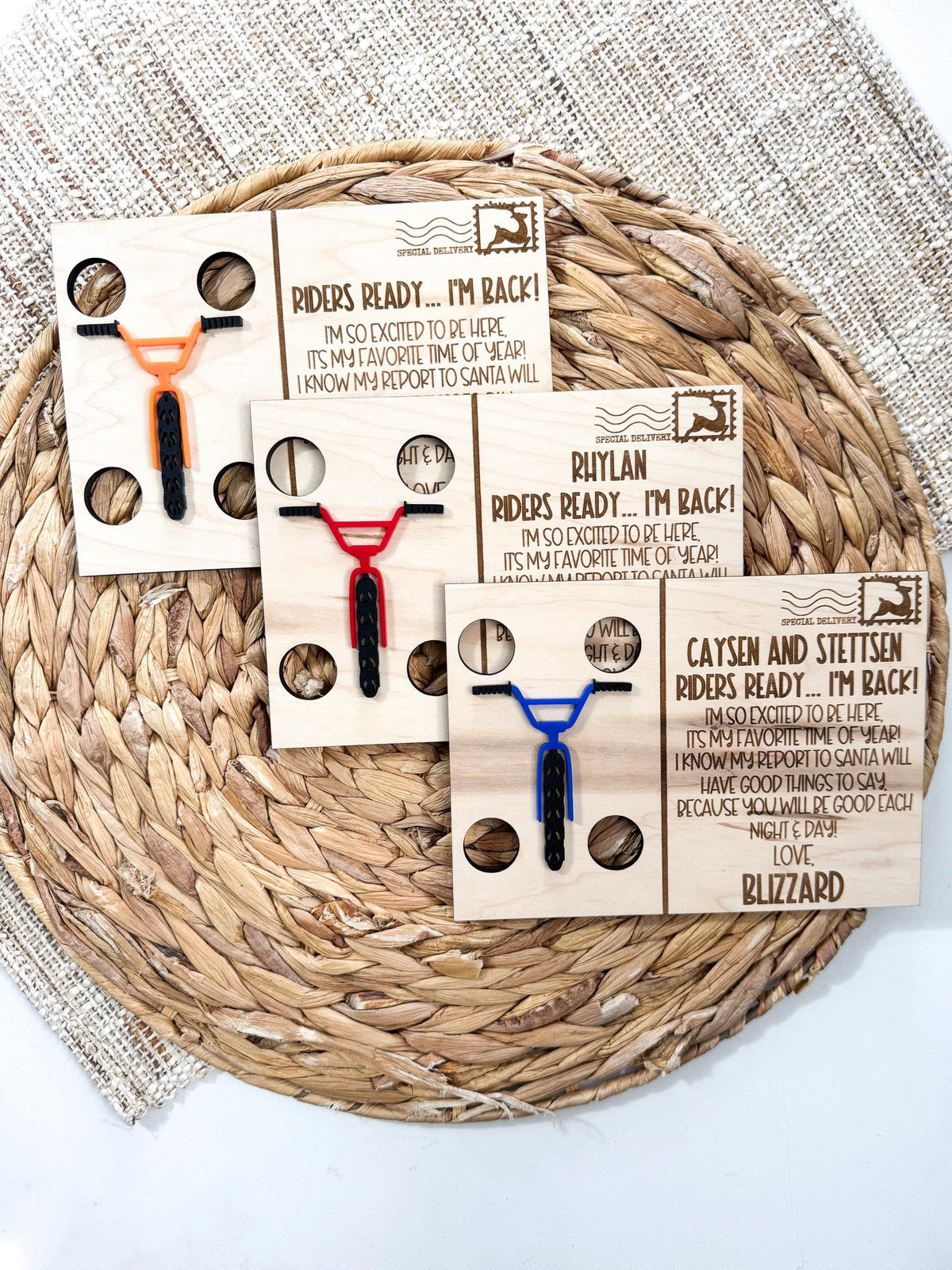 Personalized BMX elf arrival letters in three bike colors, shown from above