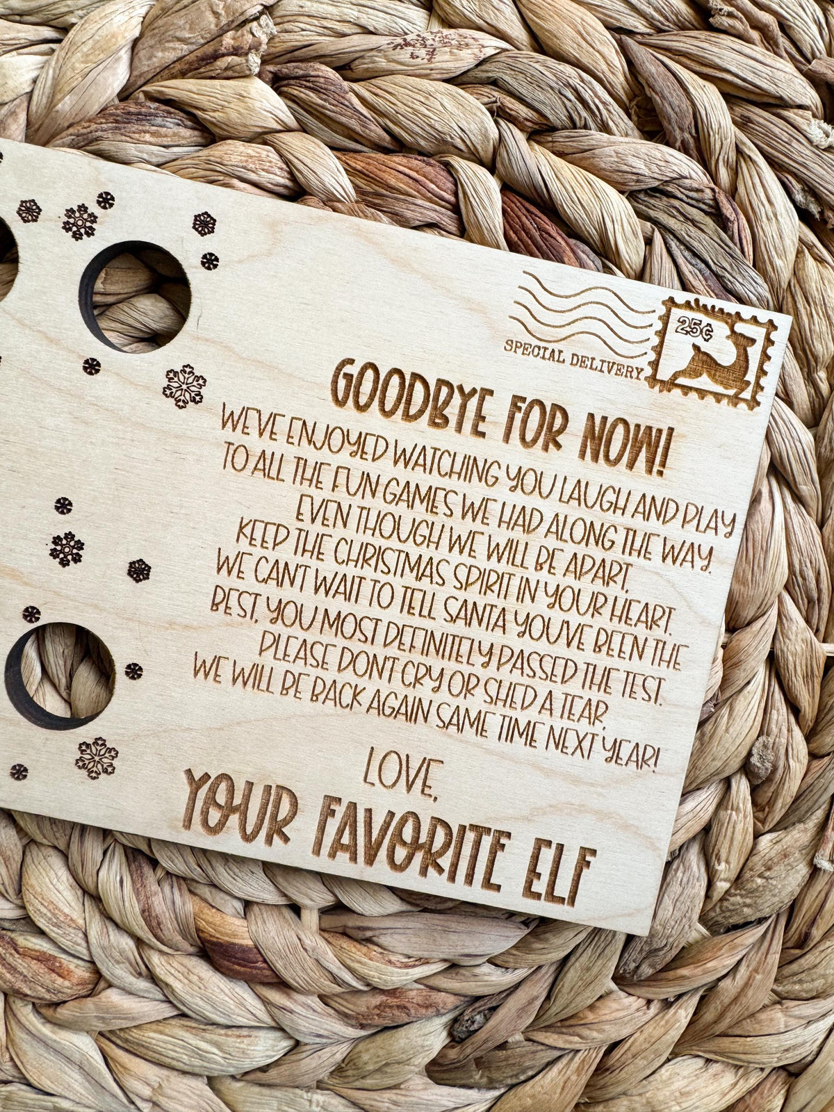 Angled view of a maple elf goodbye postcard for one elf with snowflake accents, ready for Christmas Eve