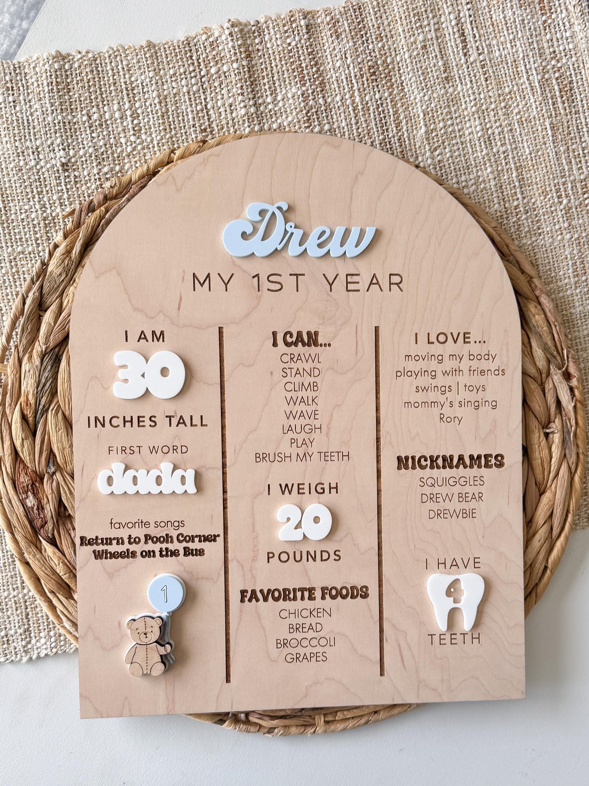 Layered acrylic baby name on maple wood milestone board with teddy bear themed birthday stats design