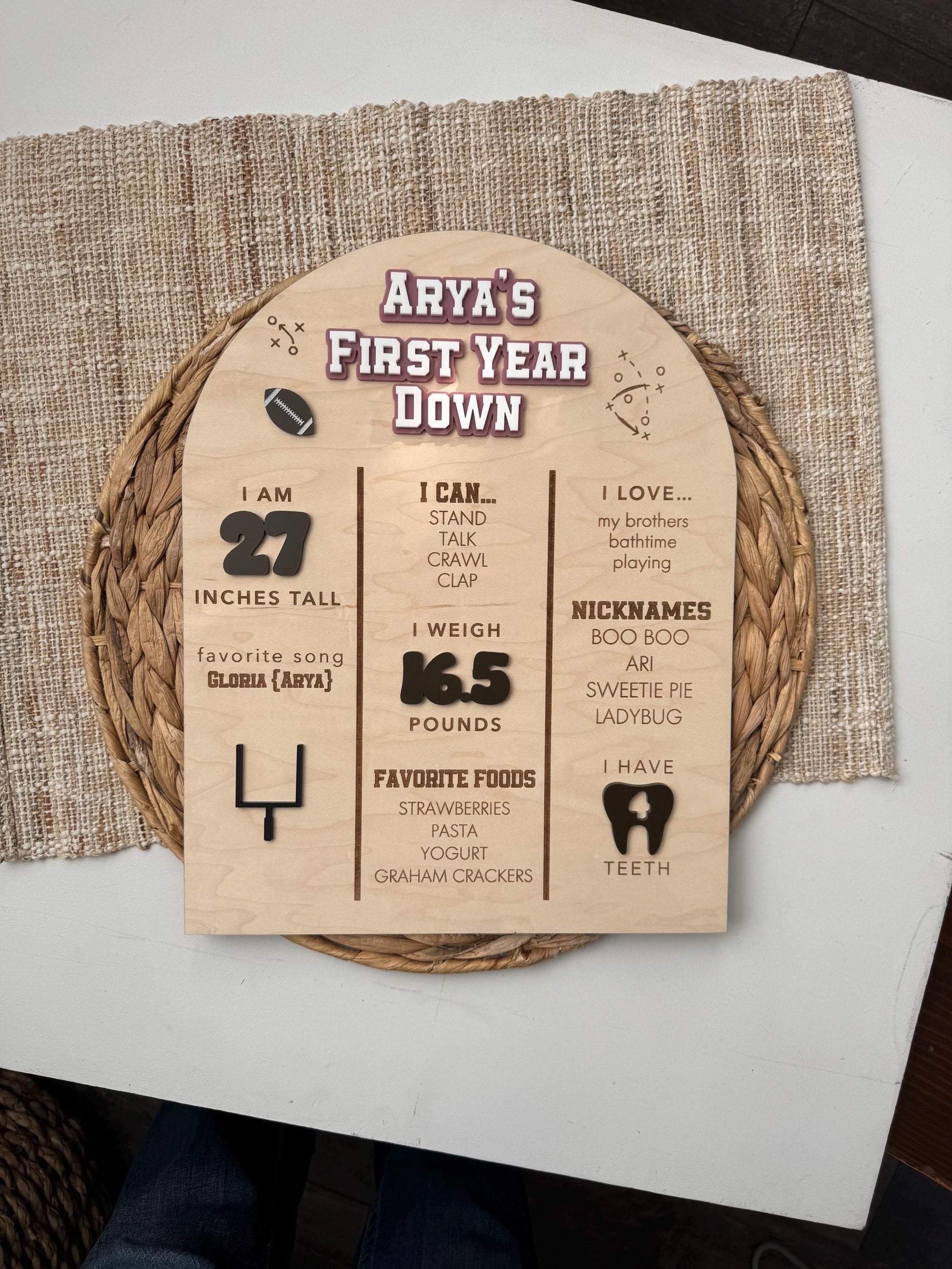 Close-up of First Year Down football milestone board with personalized baby stats