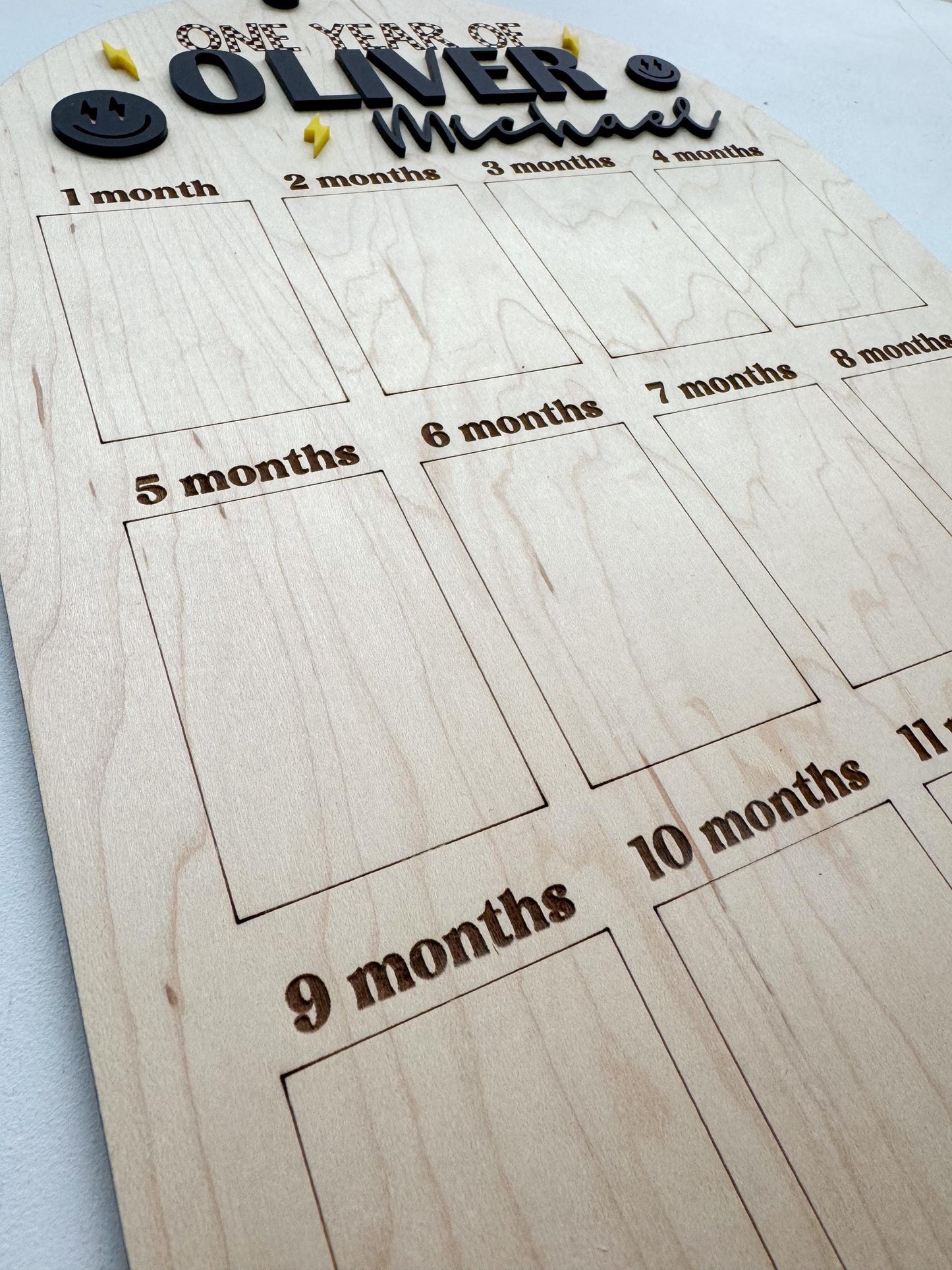 Close-up of One Year of Photos display board showing personalized name and photo slot layout