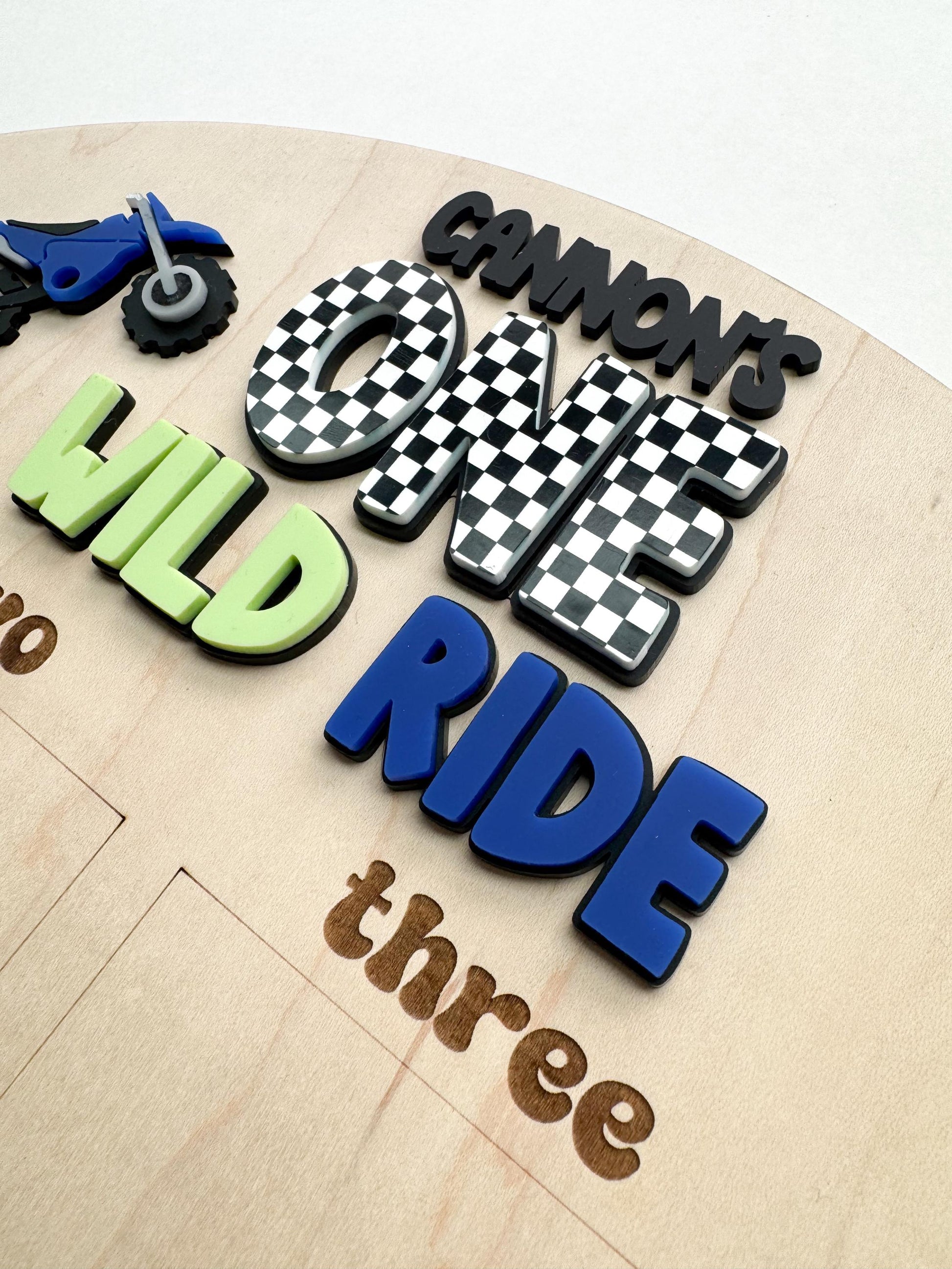 Close-up of One Wild Ride dirt bike photo board with personalized name detail