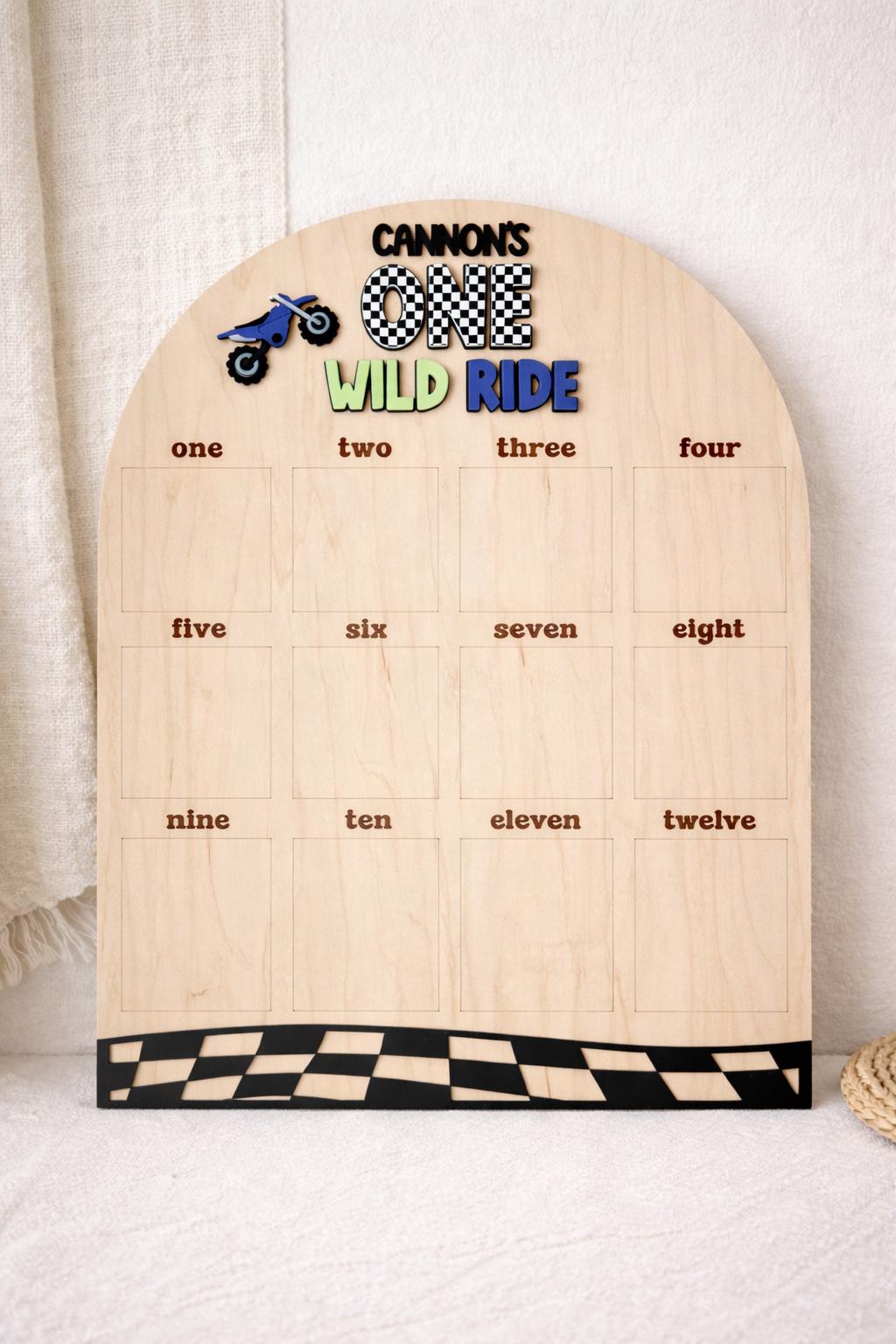 Dirt bike first birthday photo board showing 12 monthly photo slots and personalized name