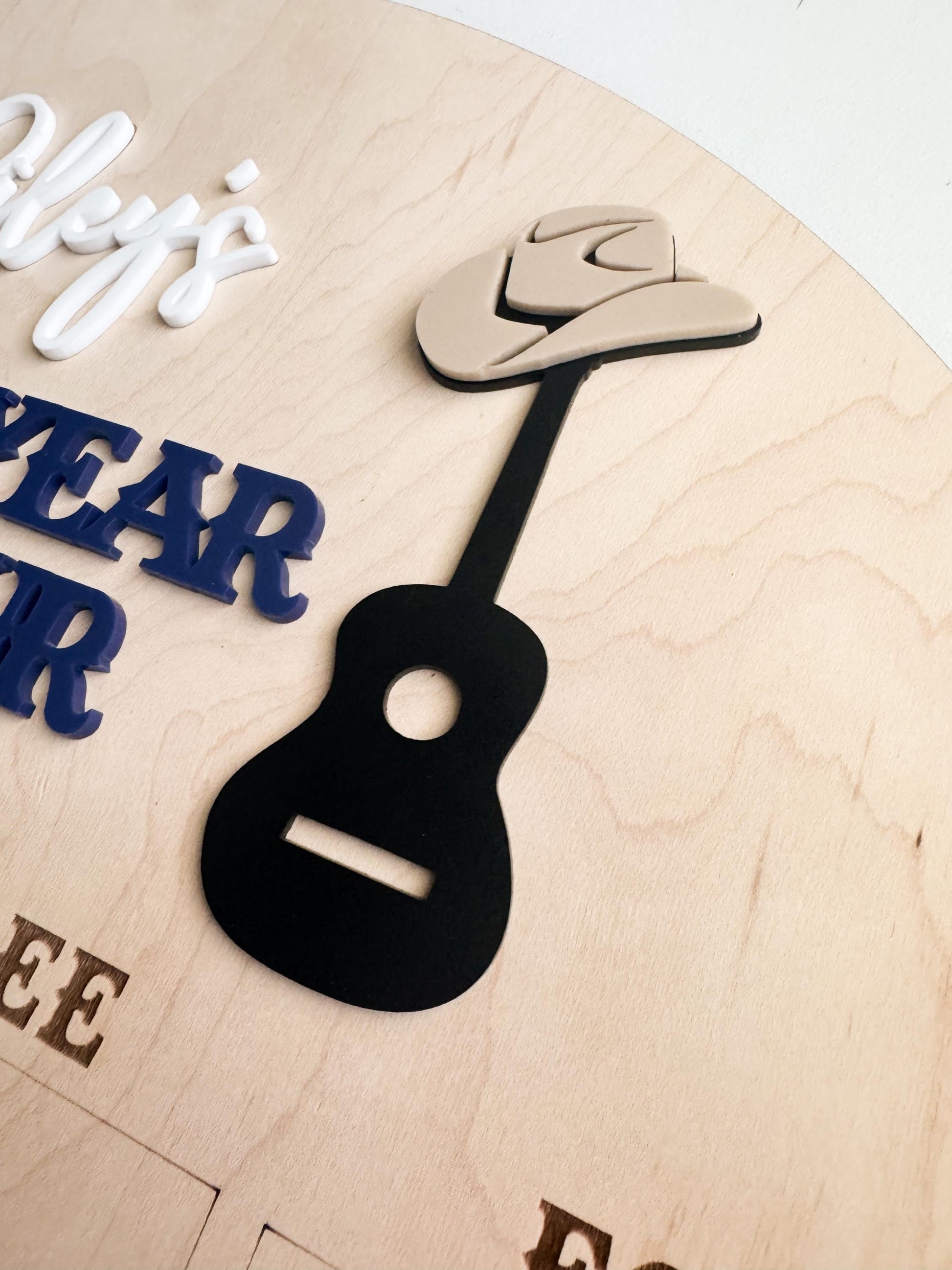 Music theme first birthday photo board showing 12 monthly photo slots and personalized name