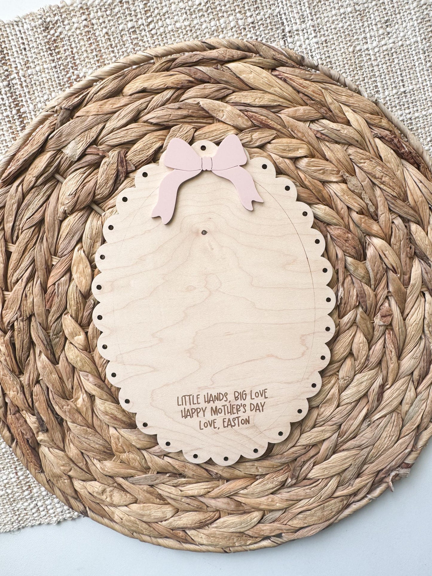 Handmade personalized maple wood handprint sign styled on a natural woven trivet as a Mother’s Day gift, with custom name and message.