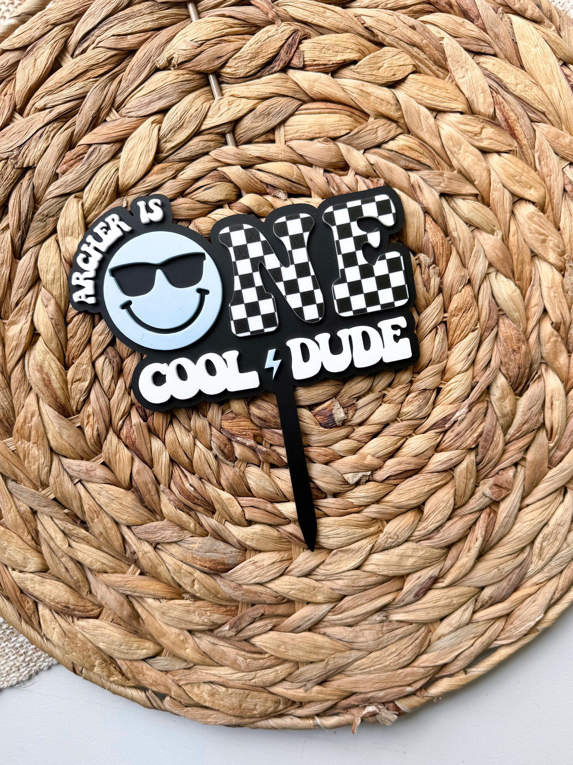 Cool dude first birthday cake topper with checkerboard letters and smiley face sunglasses