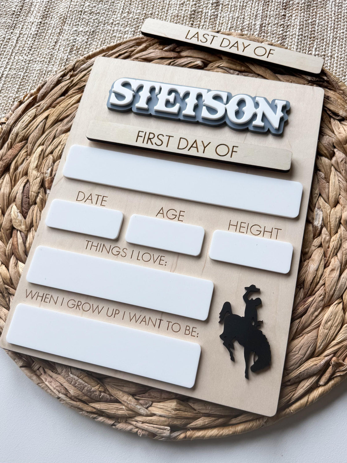 Angled photo of handmade maple wood school milestone board with interchangeable school plaques.