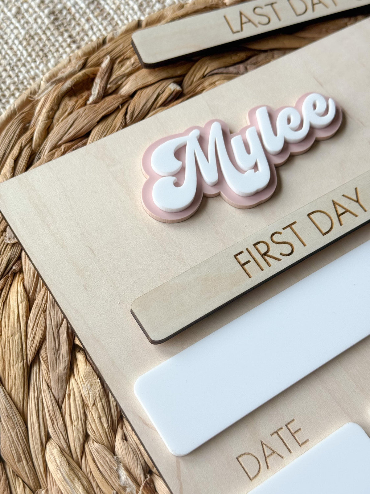 Close-up of personalized ballet school sign highlighting layered acrylic name and interchangeable first day plaque.