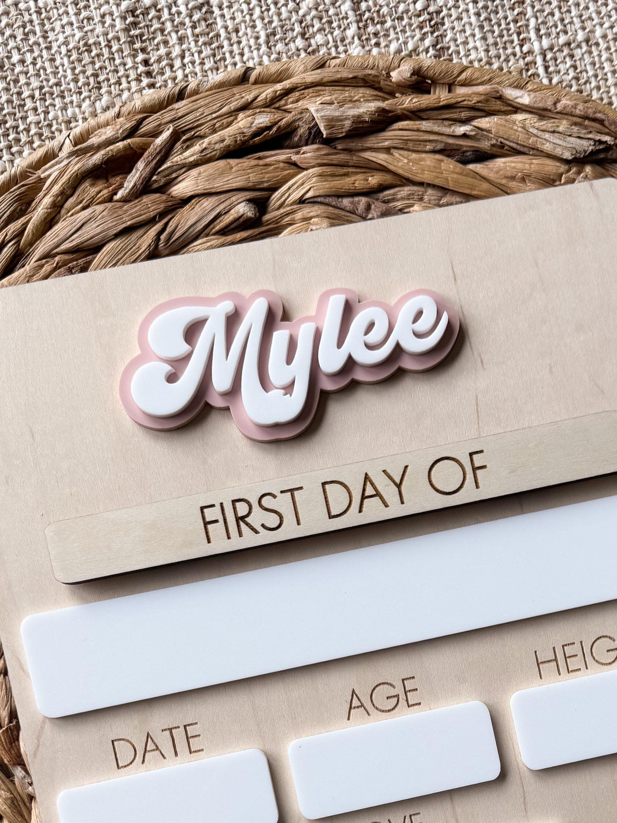 Angled view of personalized school board featuring layered acrylic name and bow detail.