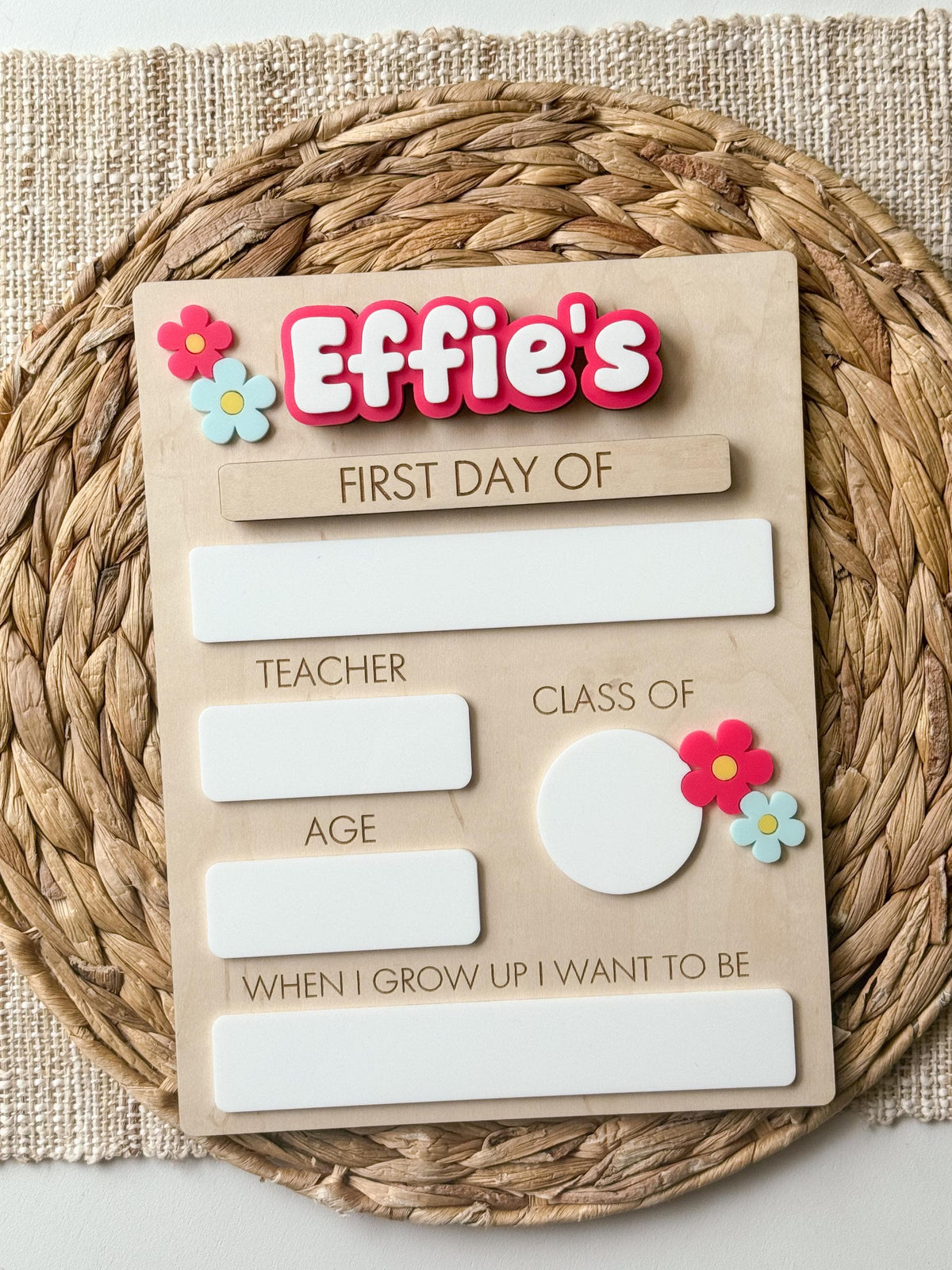 Reusable first day of school sign with pink personalized name, flower accents and dry erase school details.