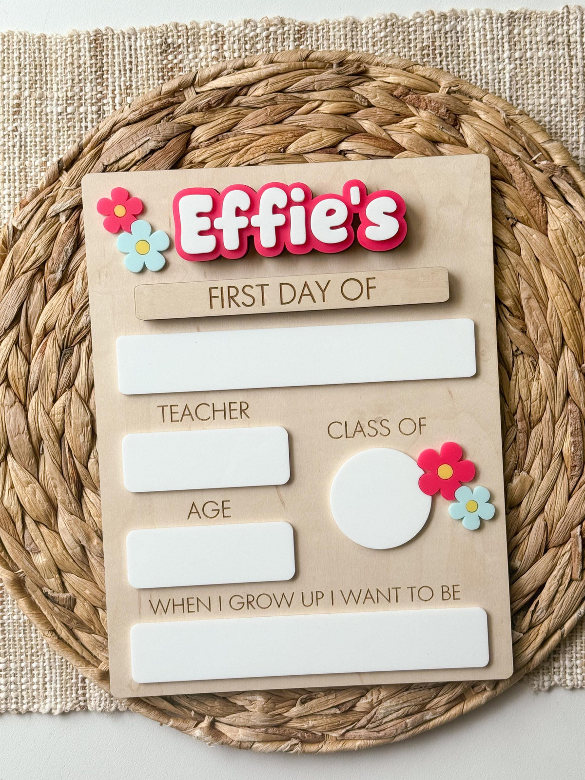 Reusable first day of school sign with pink personalized name, flower accents and dry erase school details.