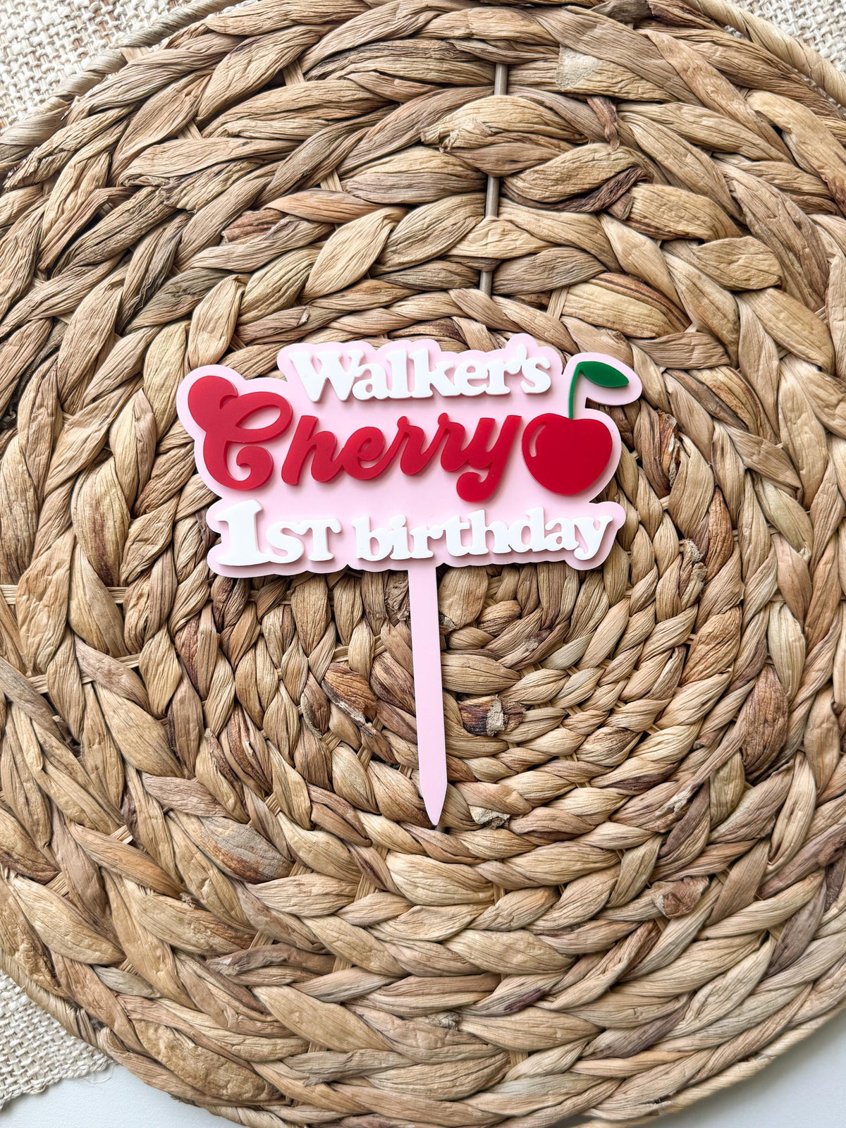 Full product view of personalized cherry birthday topper with maple wood backing and pink acrylic stake.