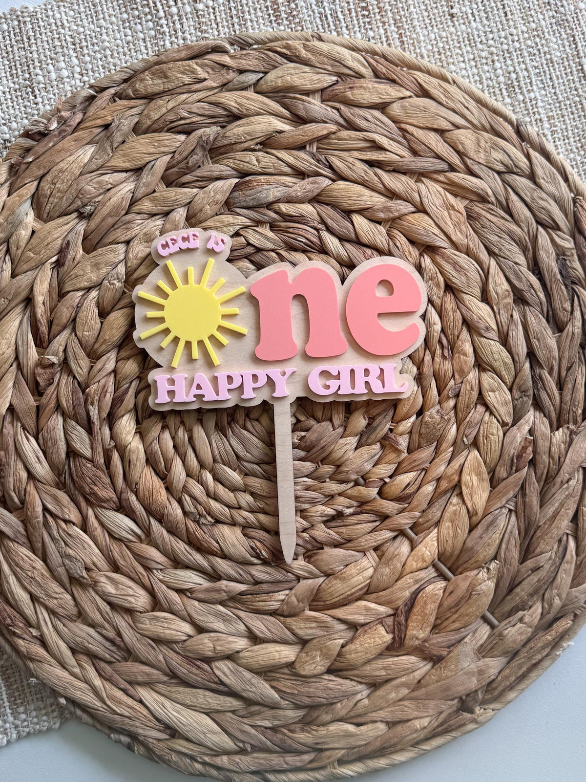 Full view of personalized sunshine cake topper for a One Happy Girl first birthday celebration.