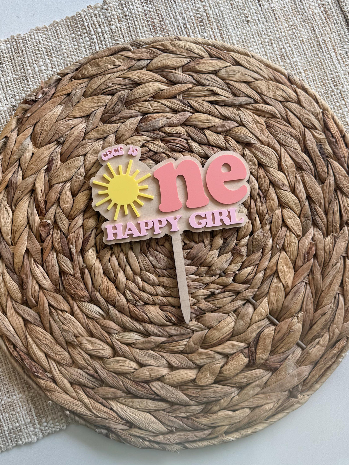 Personalized sunshine first birthday cake topper with custom name and layered acrylic lettering.