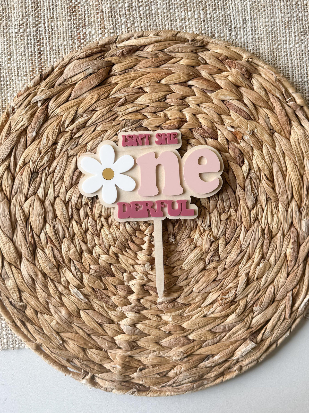 Detailed view of white daisy flower accent on personalized One-derful first birthday cake topper.