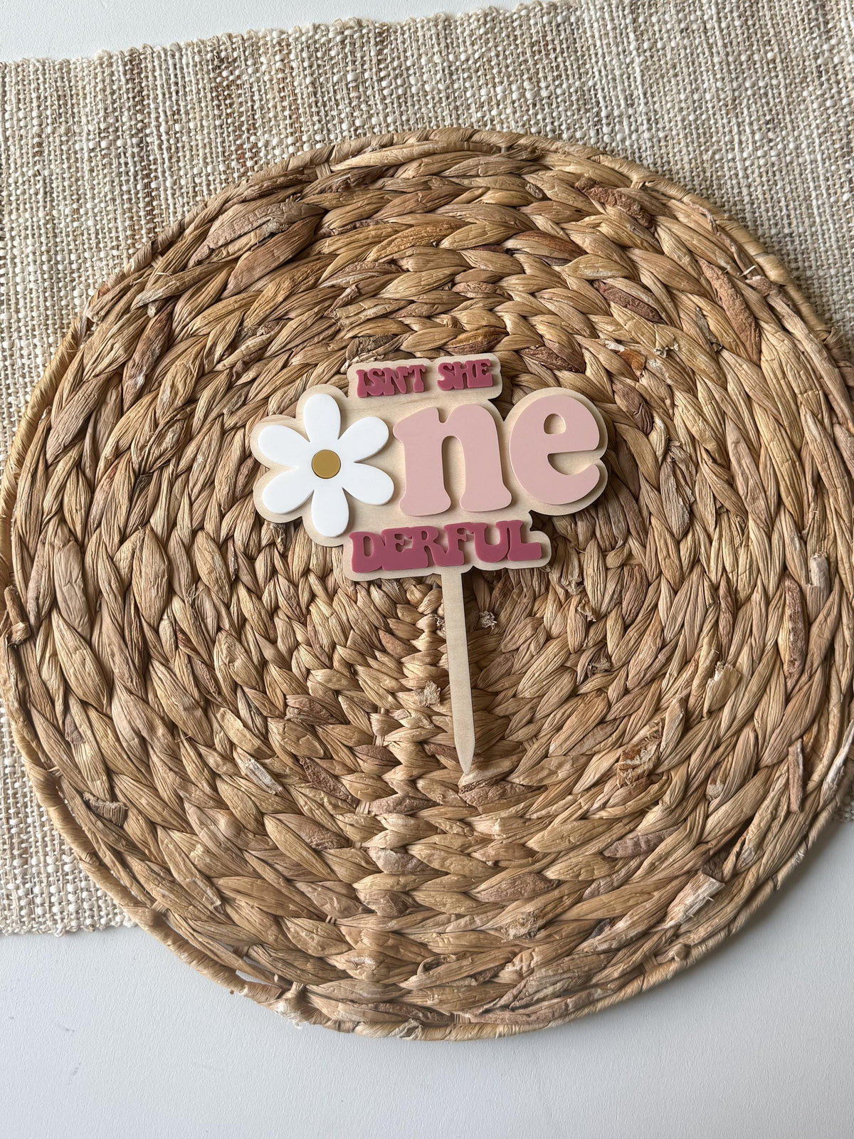 Centered view of personalized One-derful cake topper with custom name and daisy accent.