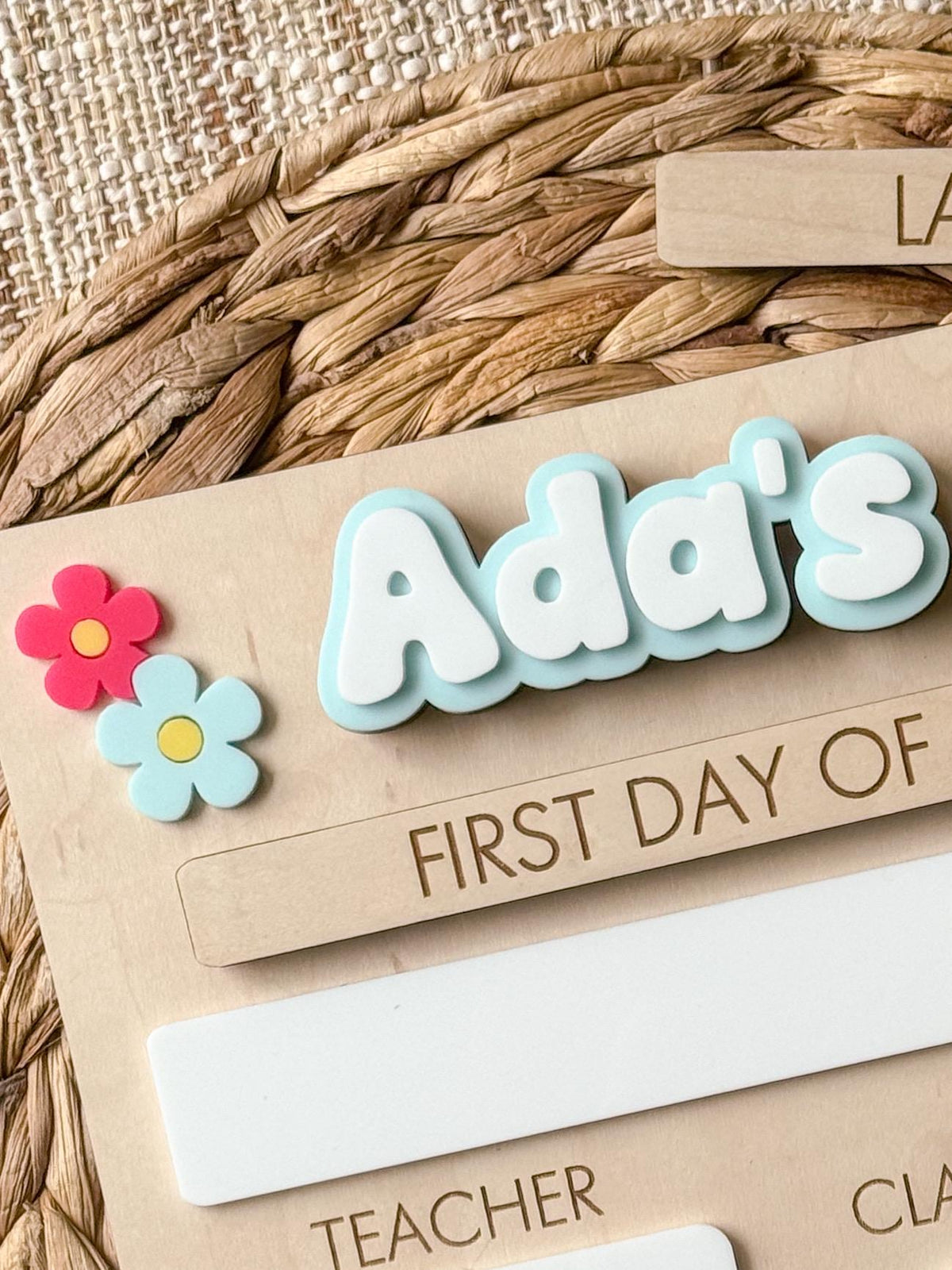 Close-up of personalized name and layered daisy details on reusable first day of school board.