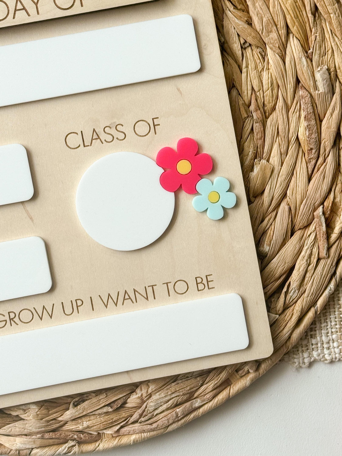 Close-up of Class Of section and layered daisy accents on personalized school milestone board.