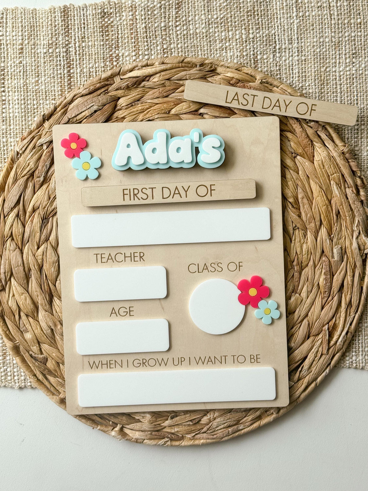 Personalized daisy school milestone board with blue name, first day piece and reusable dry erase sections.