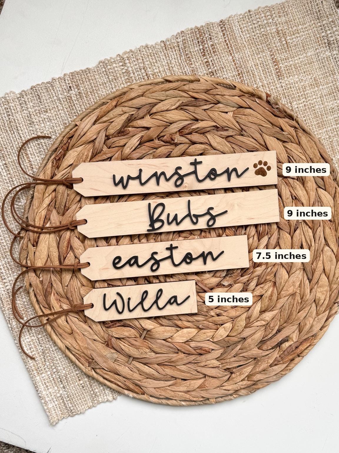 Size chart for wooden stocking name tags showing 9 inch, 7 inch and 5 inch tags with raised black acrylic script names and leather cord