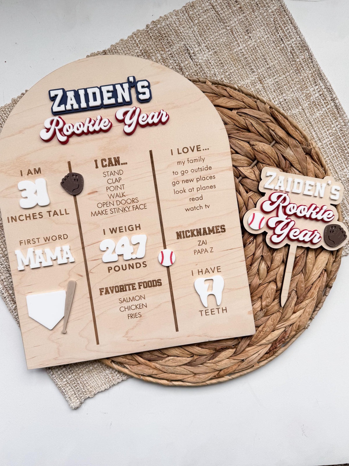 Rookie Year baseball cake topper shown with a coordinating personalized baseball first birthday milestone board with stats for height, weight, favorite foods and more.