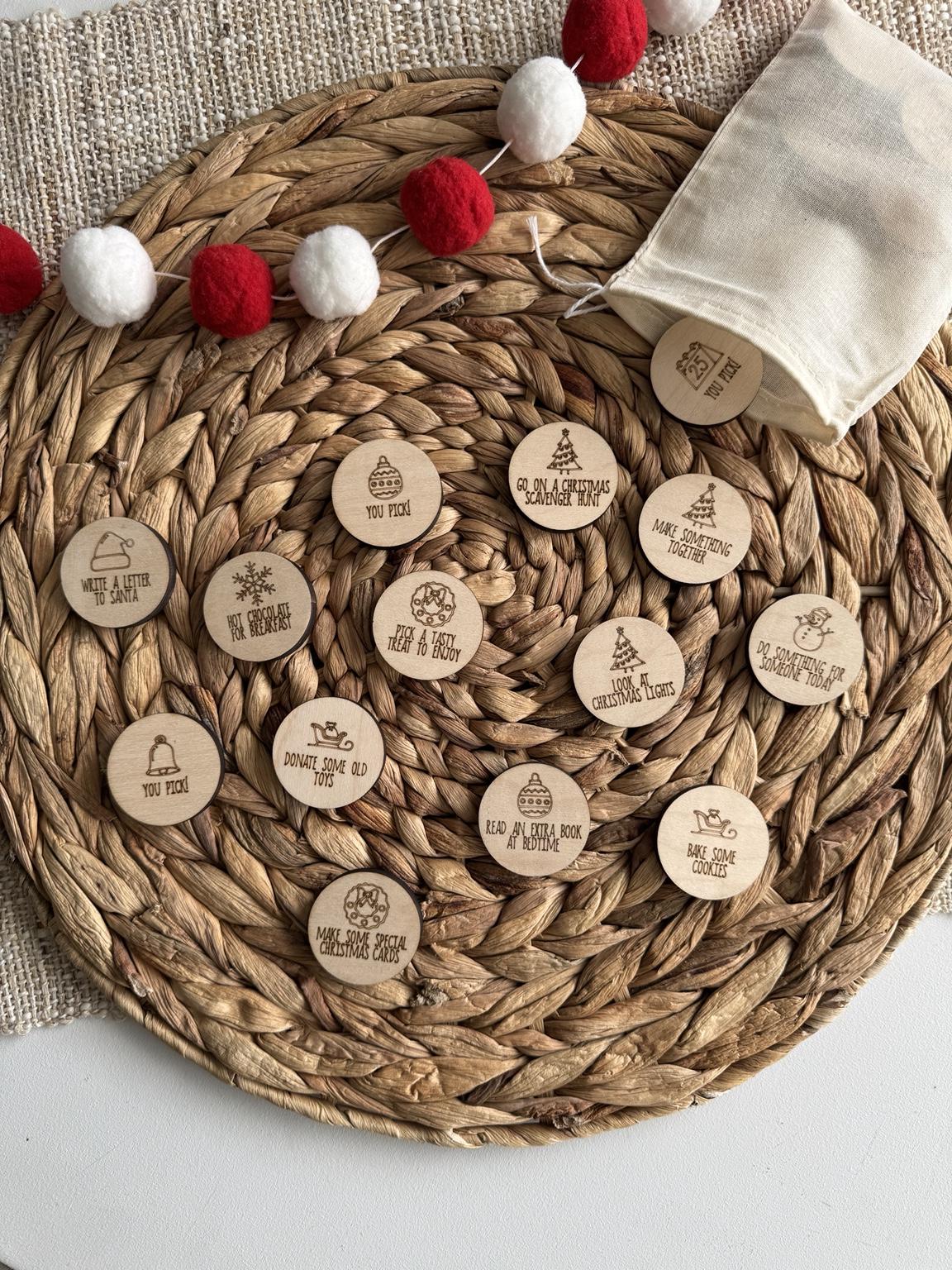 Christmas advent calendar tokens styled with a red and white garland, showing a family-friendly set of wooden activity coins such as Bake Some Cookies, Make Something Together and Go on a Christmas Scavenger Hunt.