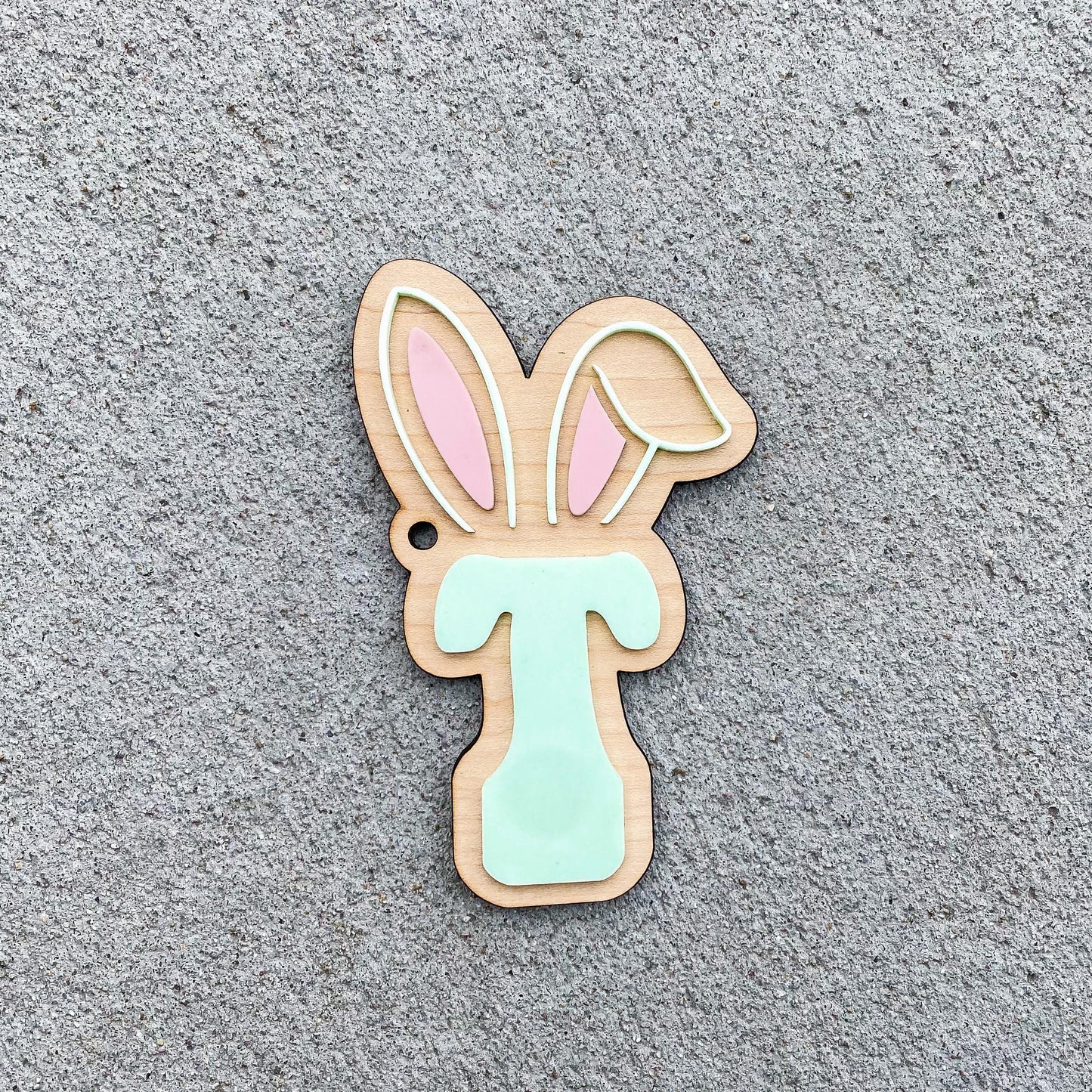 Close-up of personalized initial Easter basket tag showing engraved letter detail