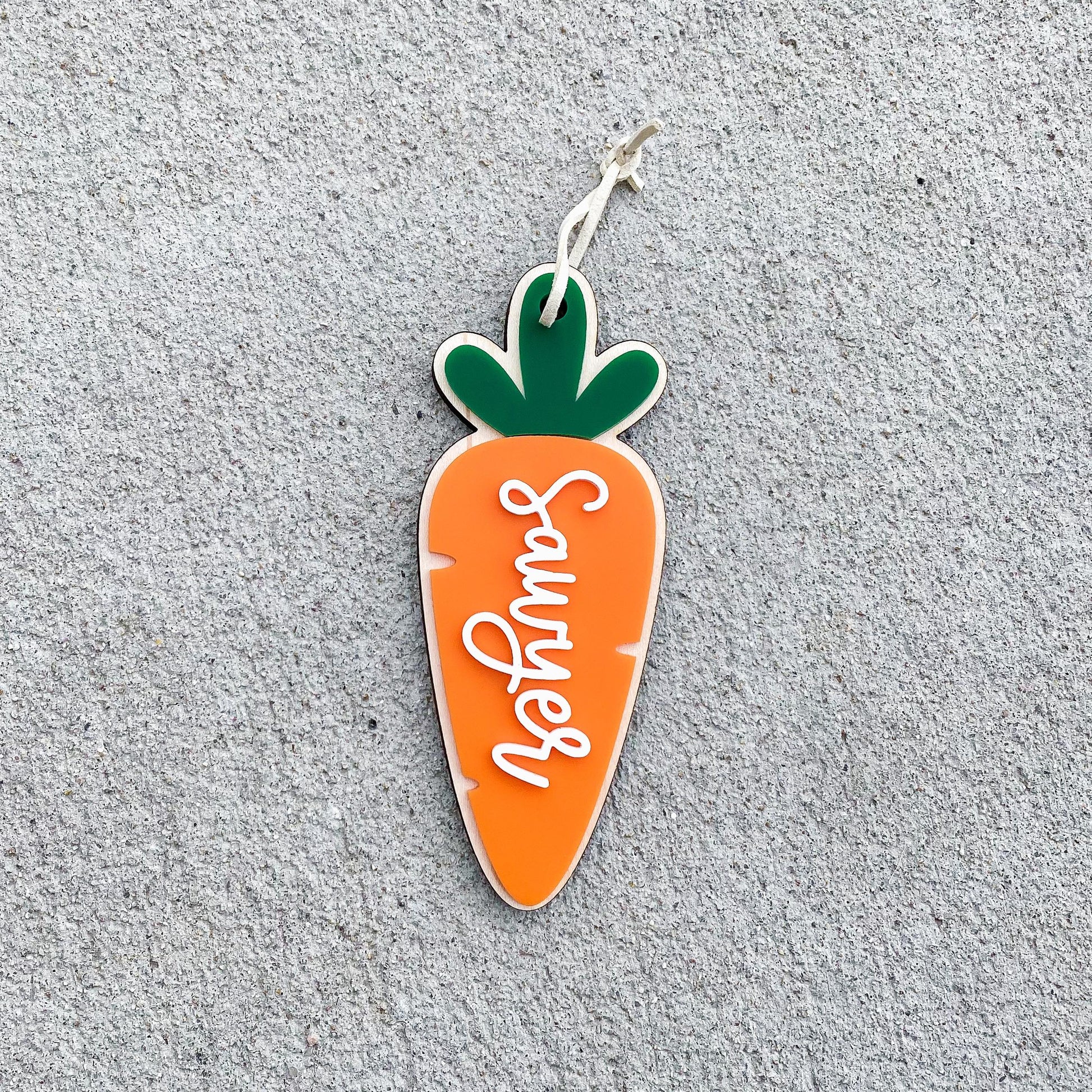 Close-up of personalized carrot Easter basket tag with name engraving detail
